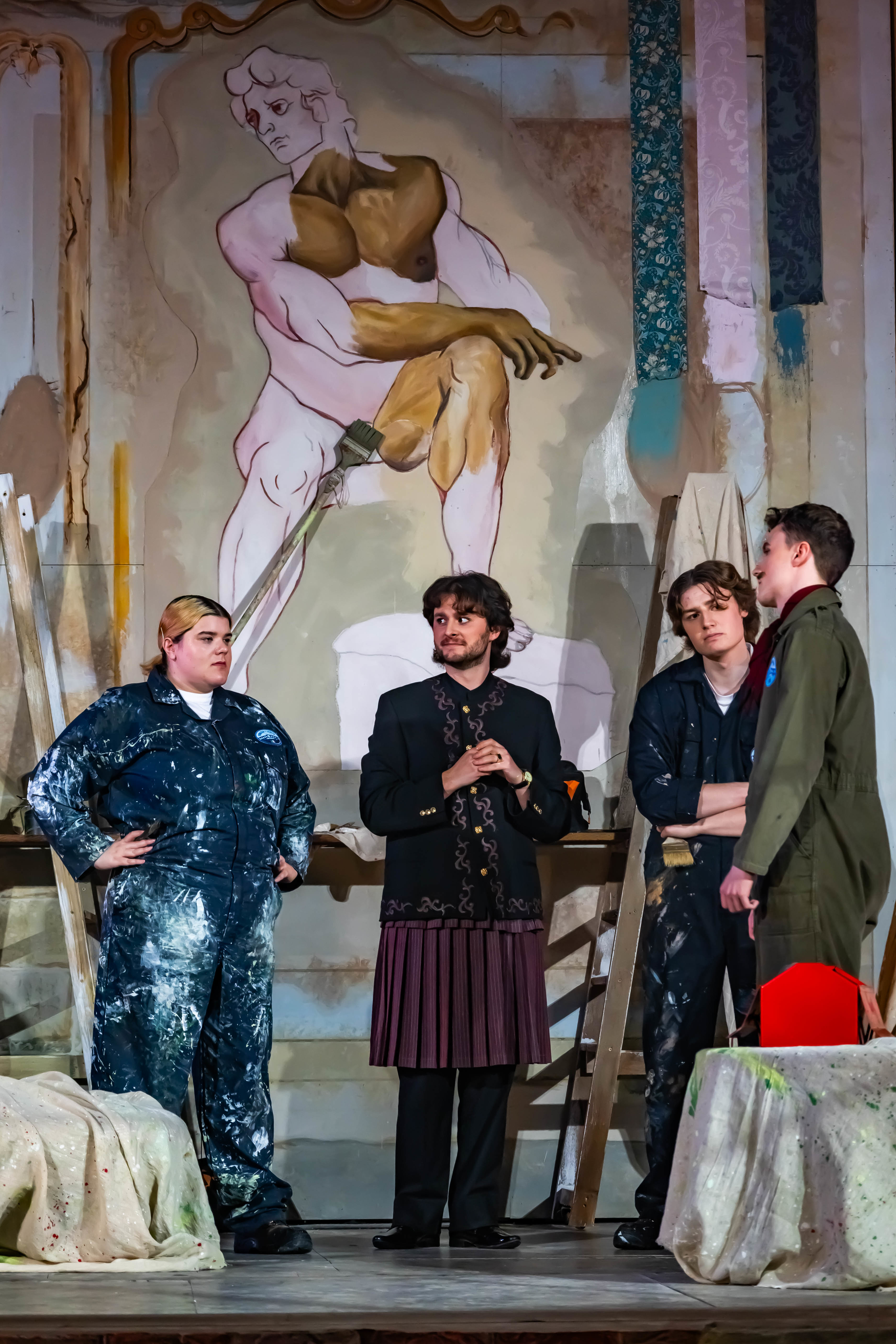 Four BA (Hons) Acting students all in contemporary costume, standing and performing a scene from La Casa Nova at Palace Court Theatre.