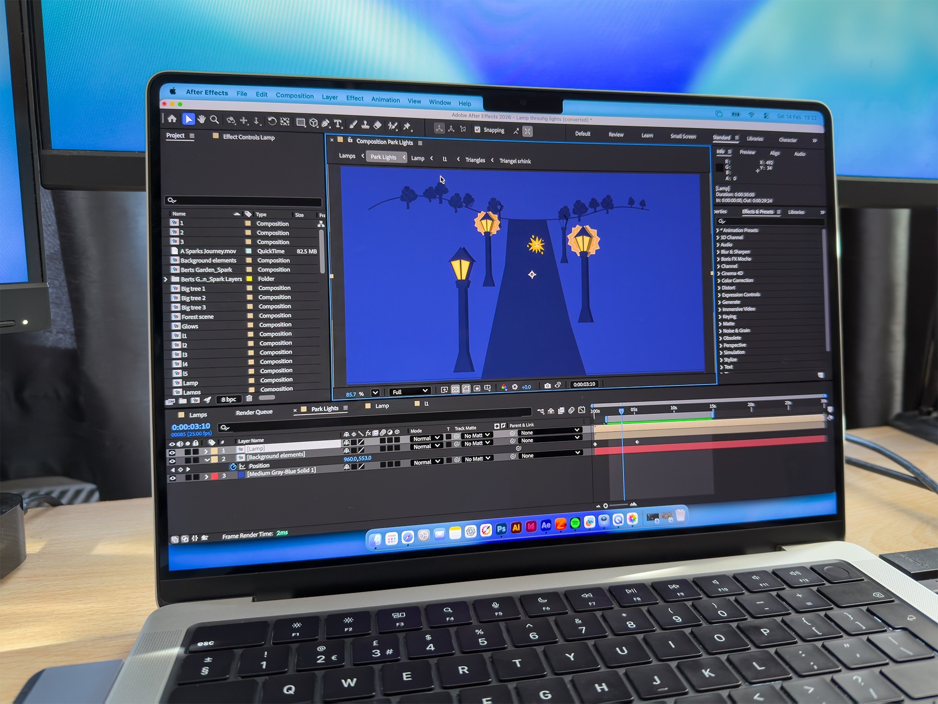 Laptop displaying video editing software with blue background scene containing yellow street lamps, timeline interface at bottom.