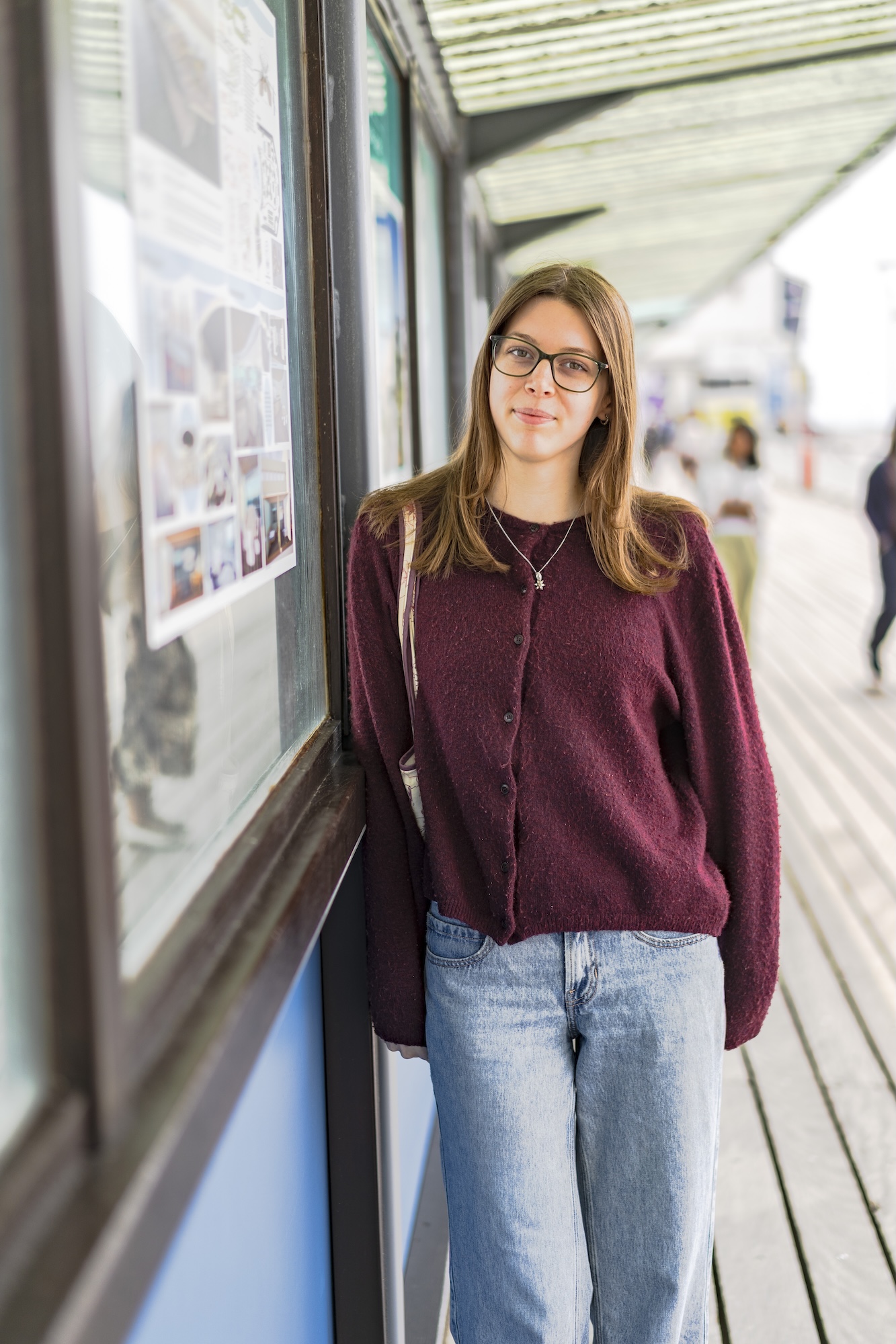 Portrait of L Harvey-Heys standing next to a display board on Bournemouth Pier.