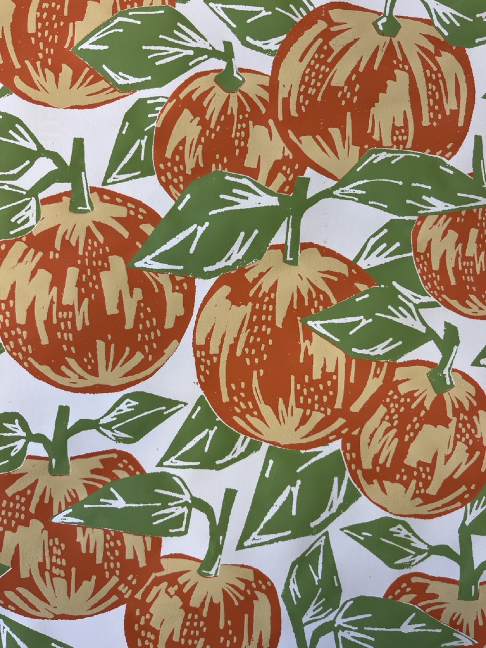 A pattern featuring numerous orange fruits, resembling oranges, with textured skin and green leaves, set against a white background. The fruits are arranged in a repeating design, showcasing their round shape and leaf clusters.