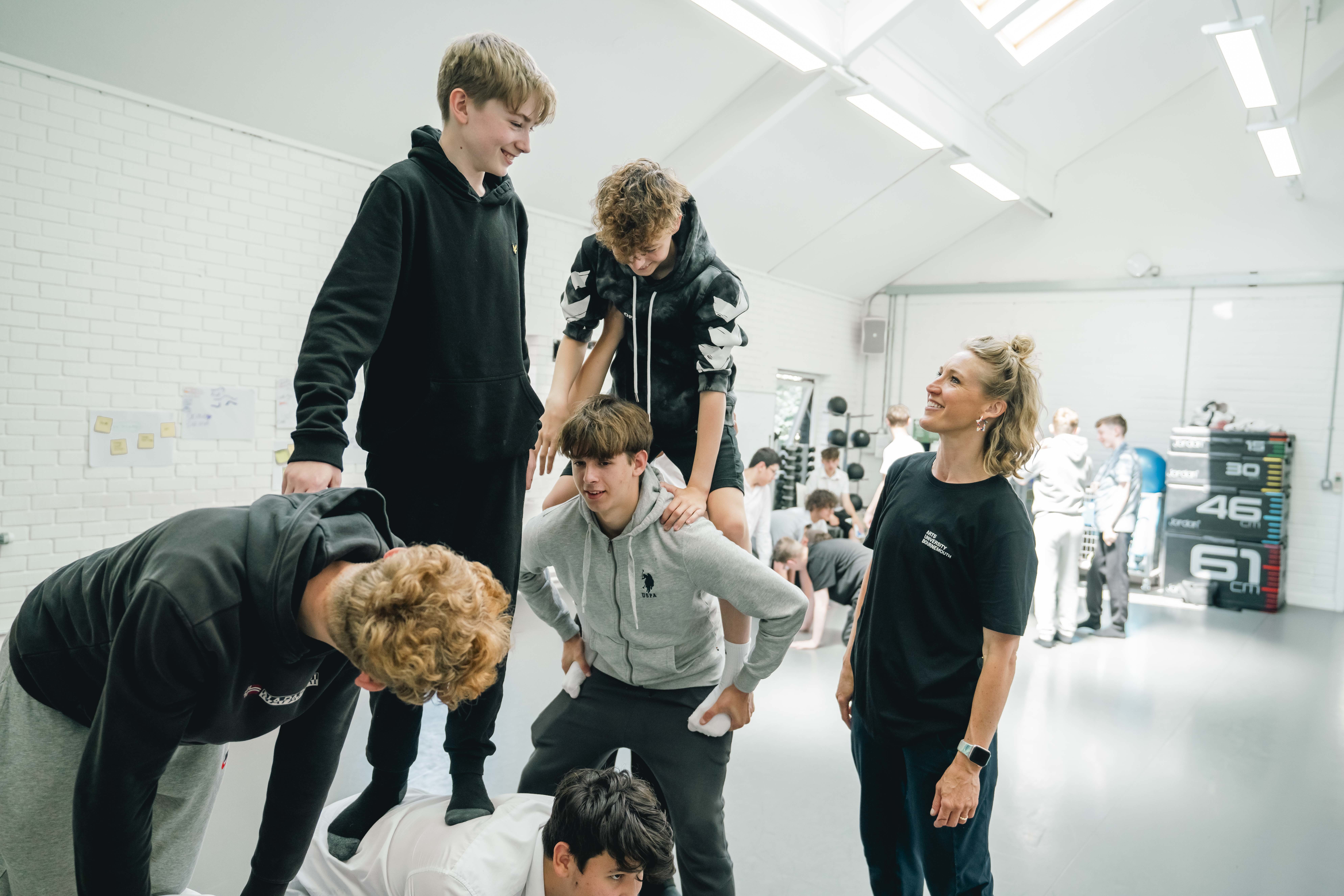 Students practising lifts as part of a movement workshop in a dance studio.