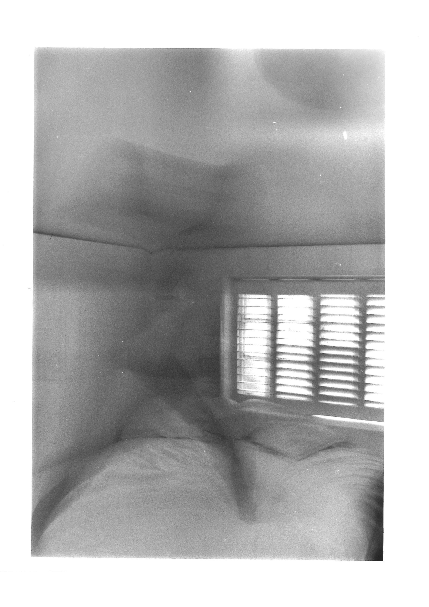 A blurred figure running across a bed.