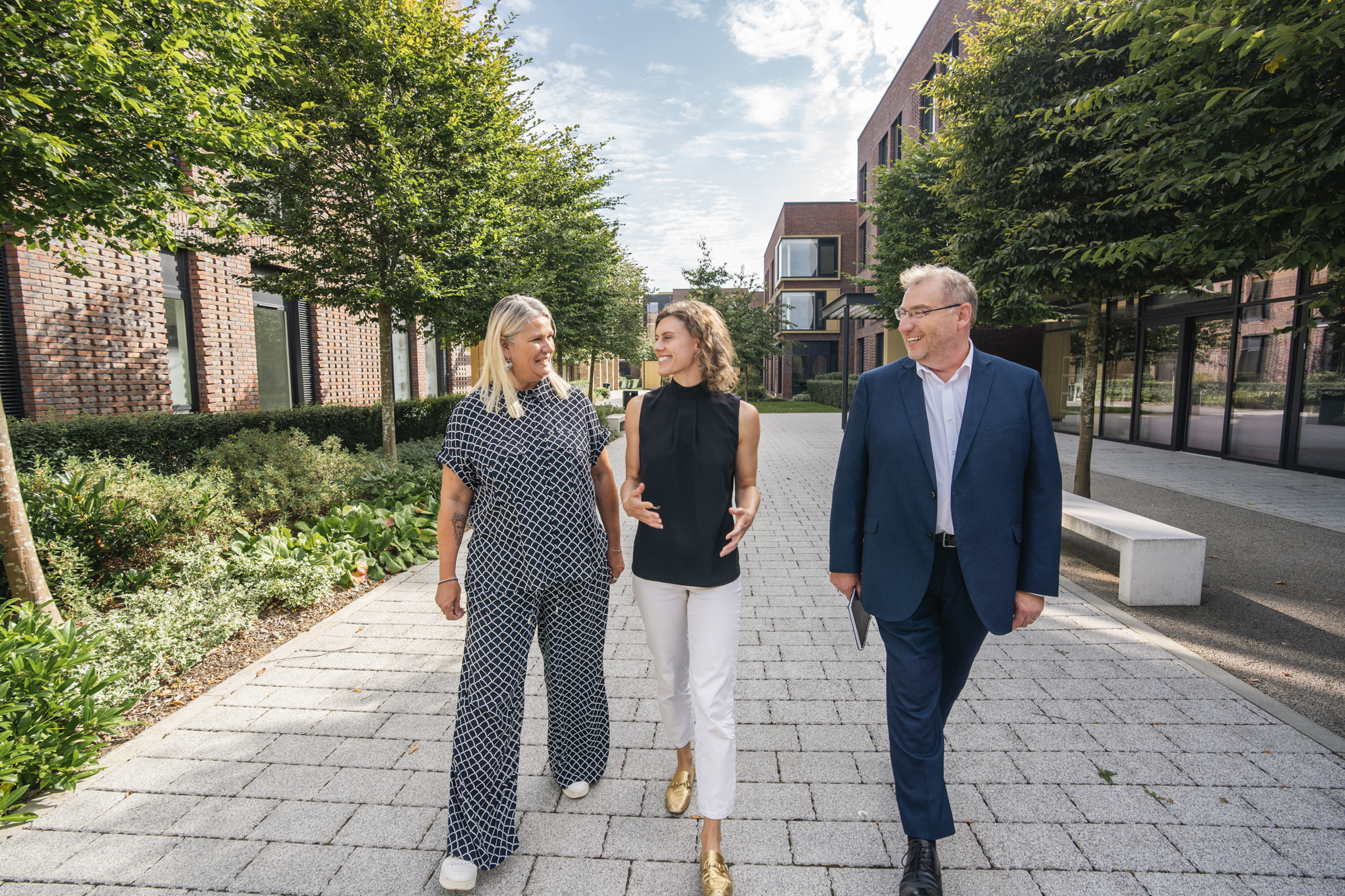 L. Mann, J. Toale MP and S. Harvey walking outside Campus Halls on AUB Campus.