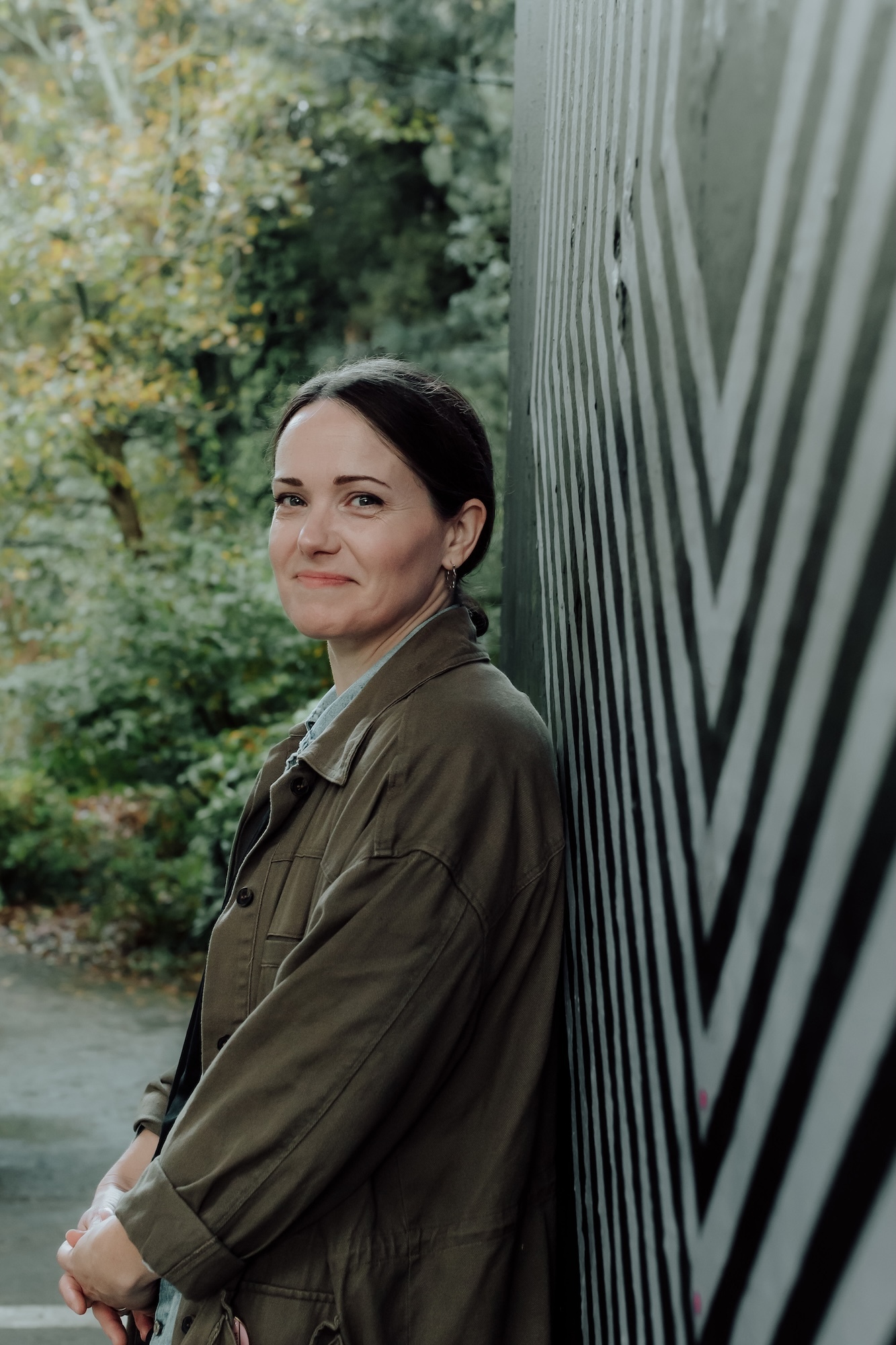 L Flynn standing beside metal railings with trees in background