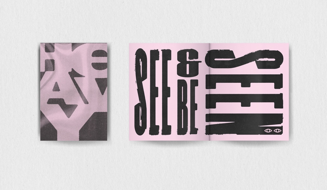 Mock-up of a booklet with typographic black text: 'See & be seen' and 'HEAVY' on a pink background.