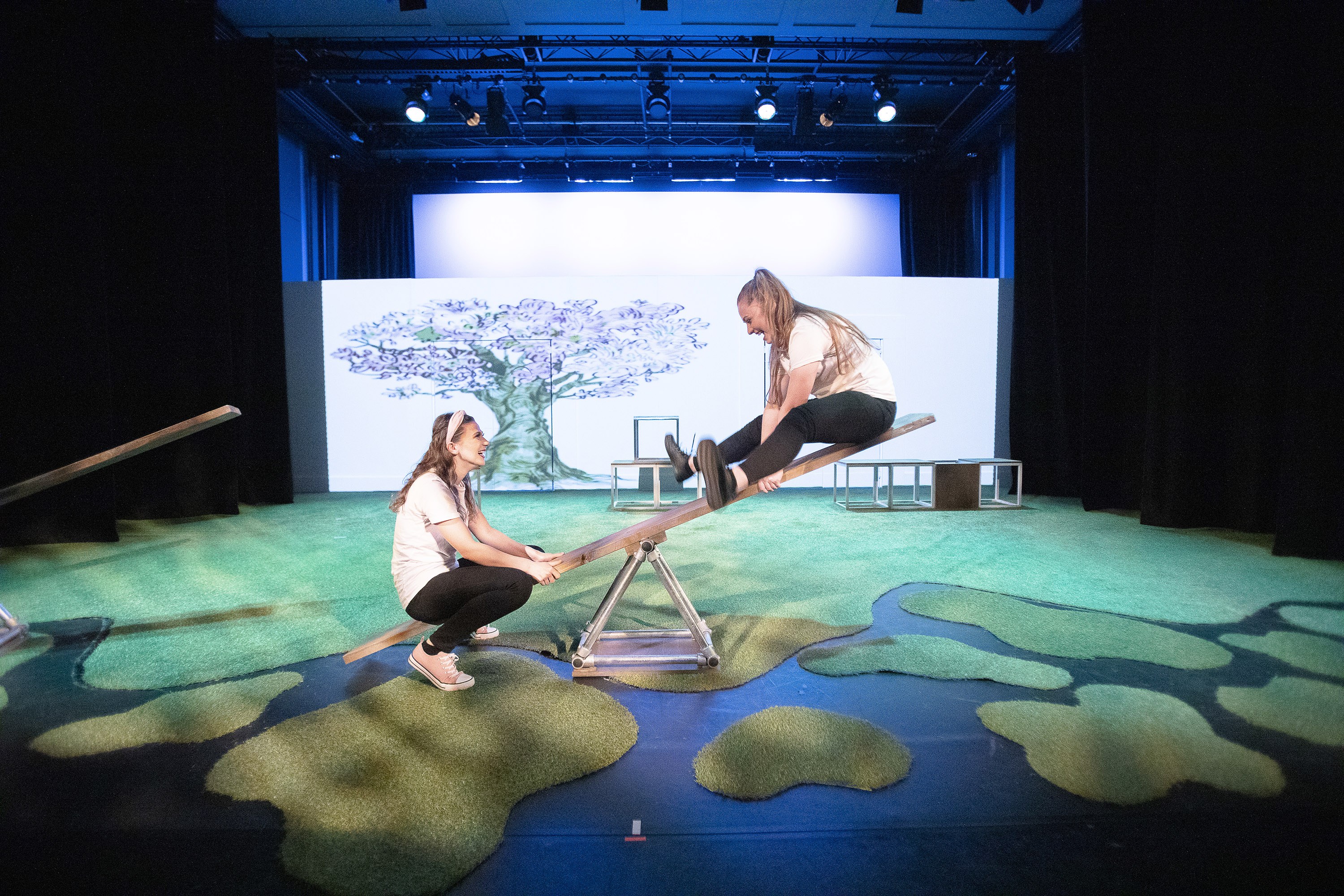 Student acting on a seesaw in a production of Love and Information