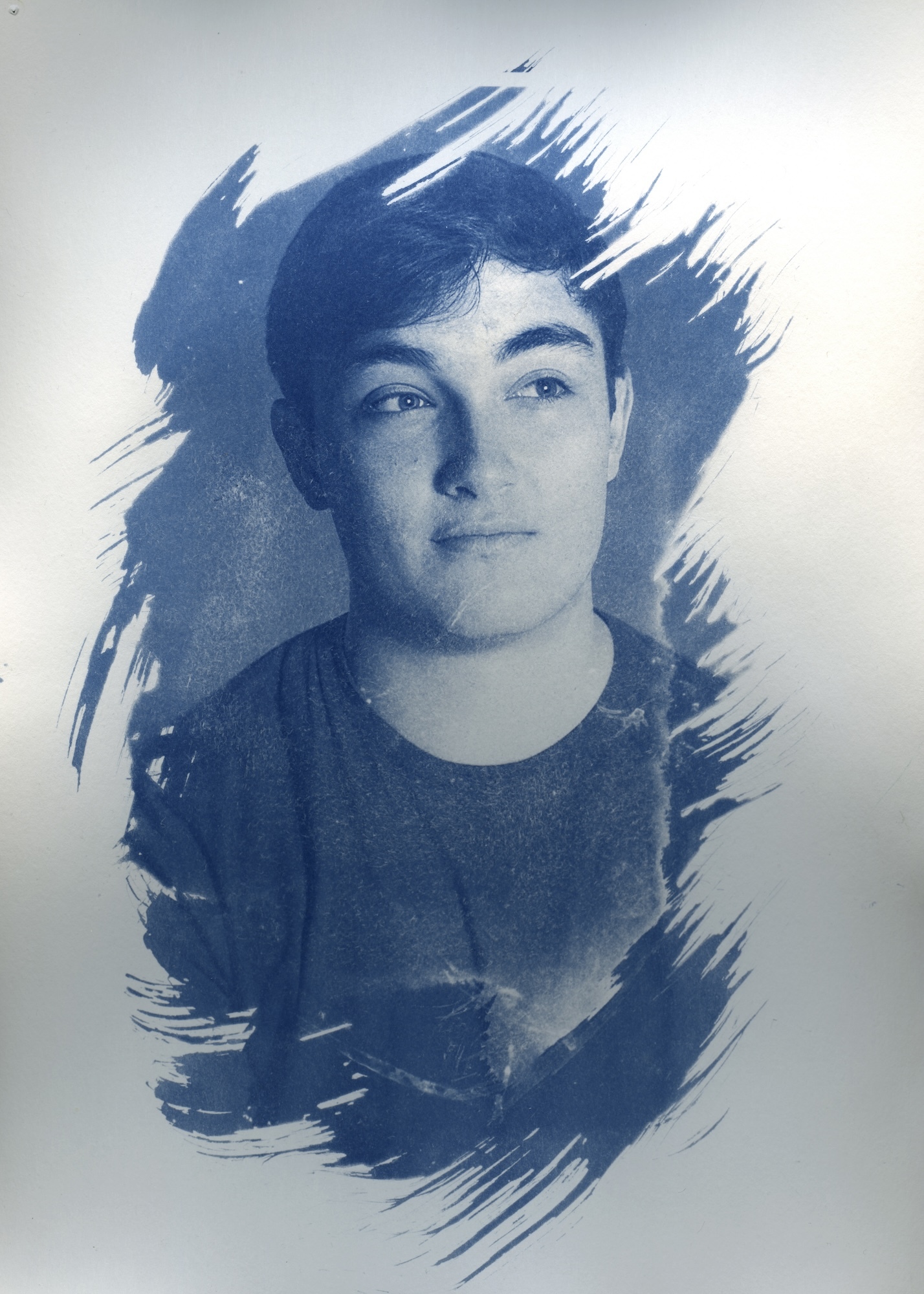 Cyanotype photograph of a young male looking away from the character. A thick brushstroke effect has been applied to the edges.