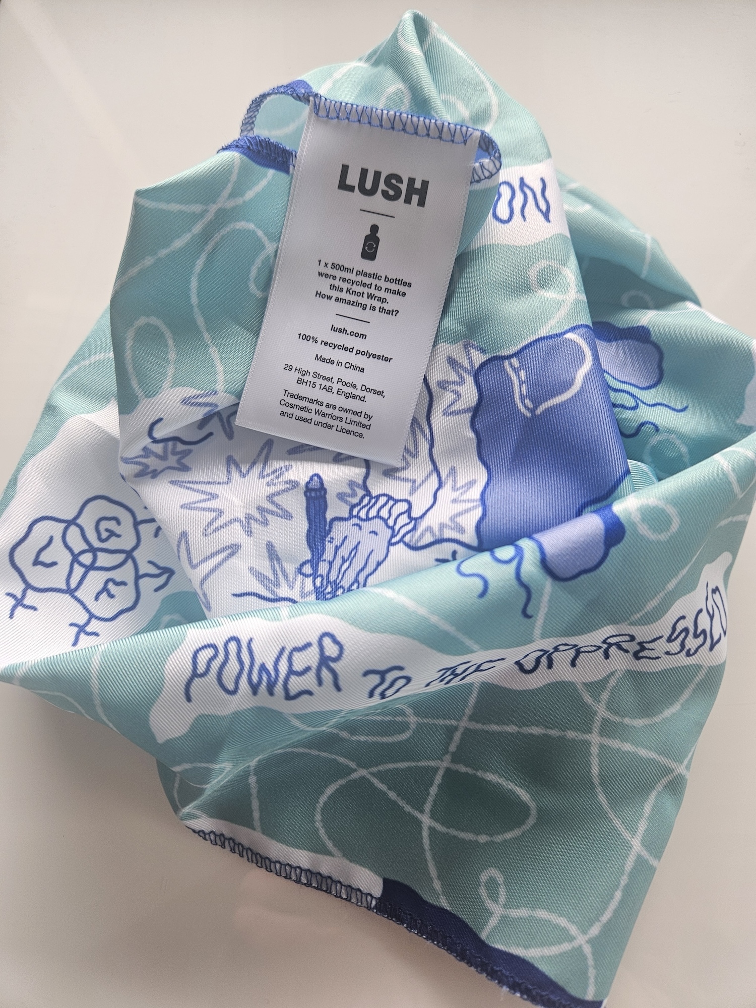 Close-up of a blue and white fabric wrap with the label, showing the LUSH logo, on show.