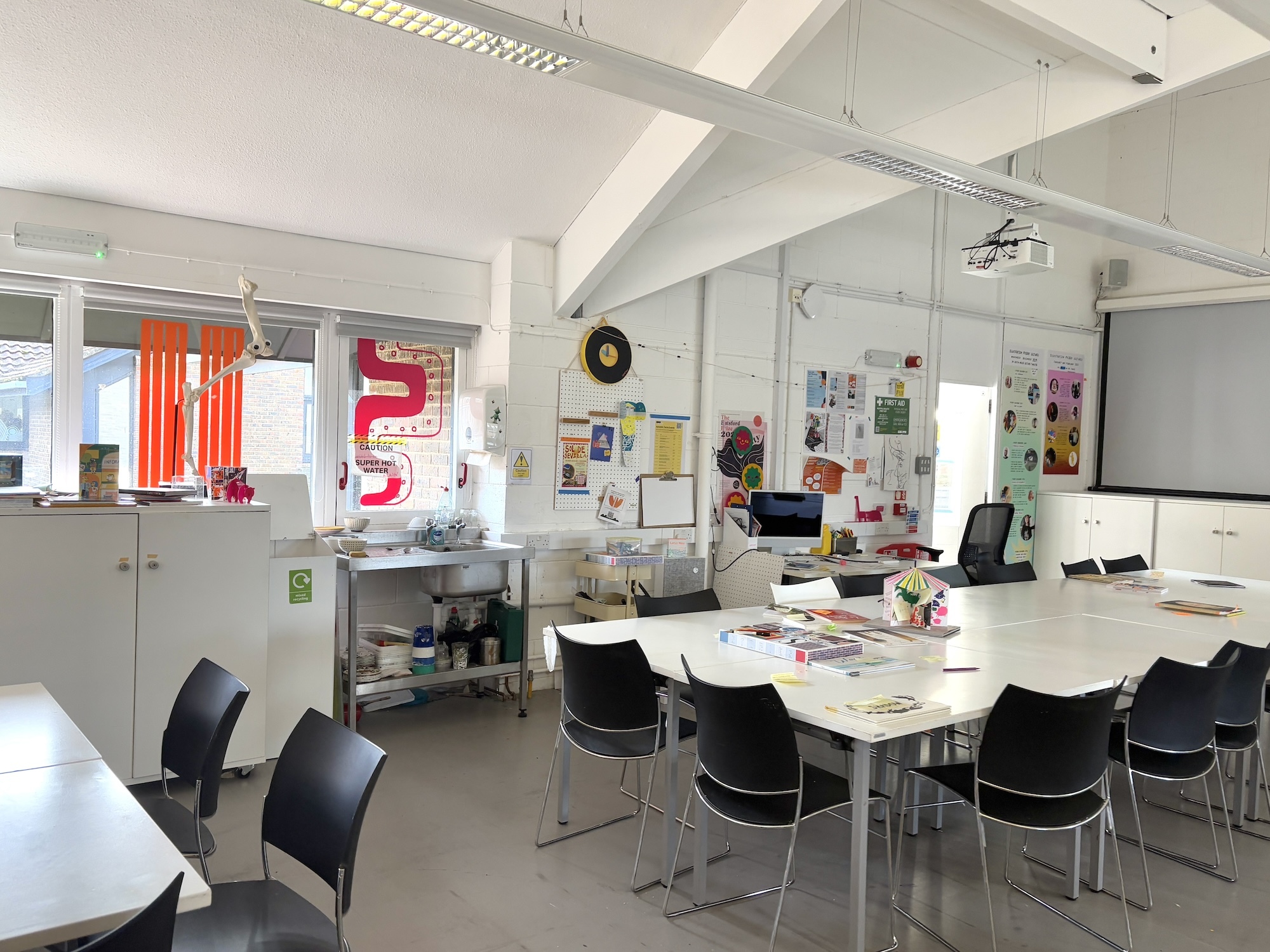 A pair of tables with a series of chairs around them in an empty studio space at Arts University Bournemouth.