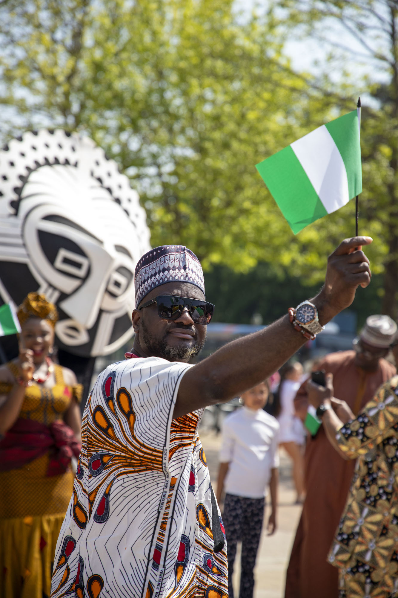 An attendee of the Alice in Spring 2024 event holding up a Nigerian flag.