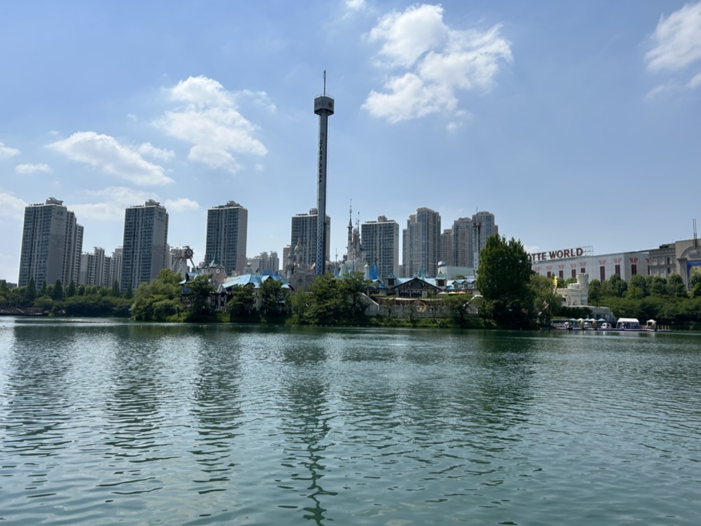 A cityscape of Seoul, South Korea, with several tall buildings and greenery all viewed across a large river.