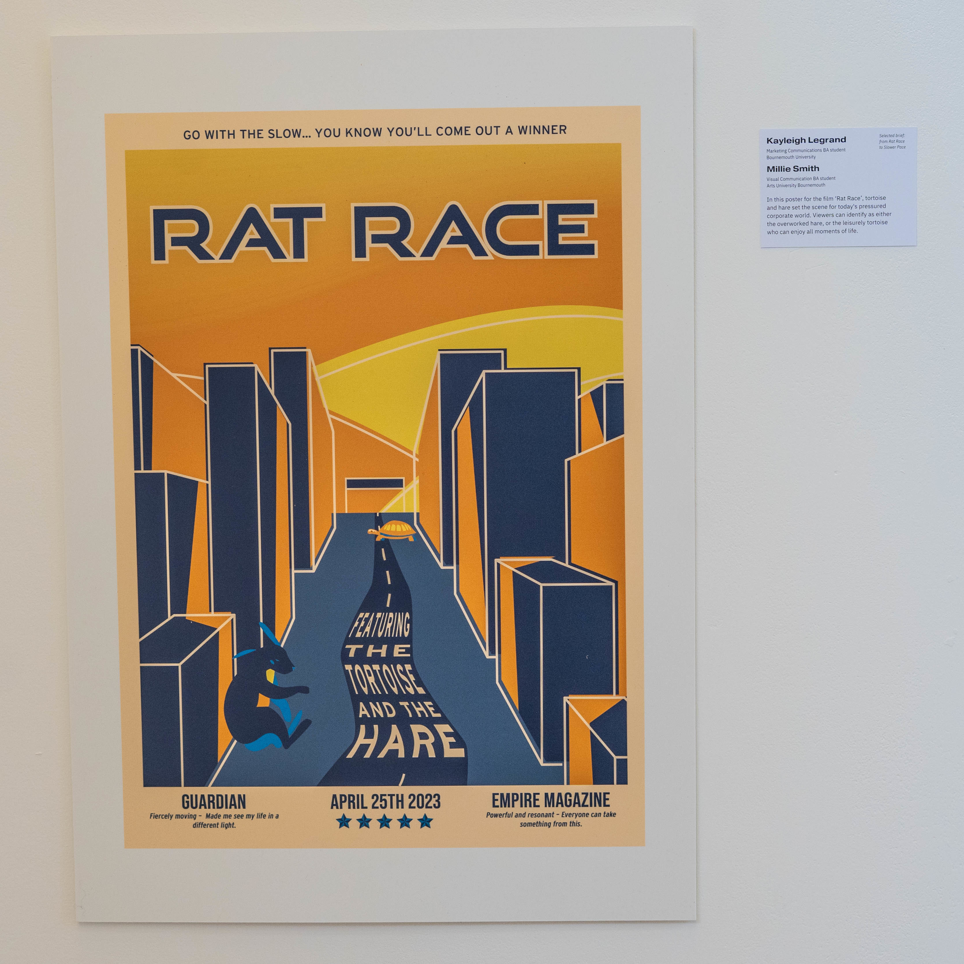 Film poster with title "Rat Race" displayed on a gallery wall.