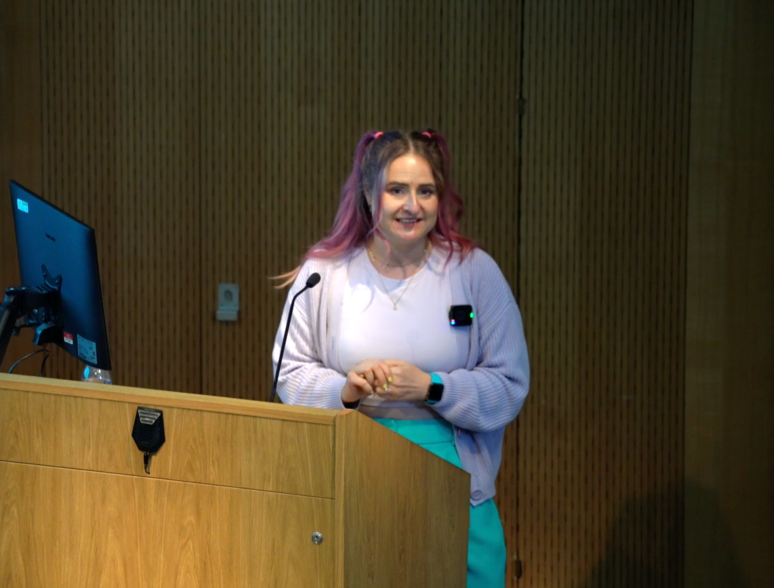 Calligrapher M Withers standing at a podium giving a talk at Arts University Bournemouth.