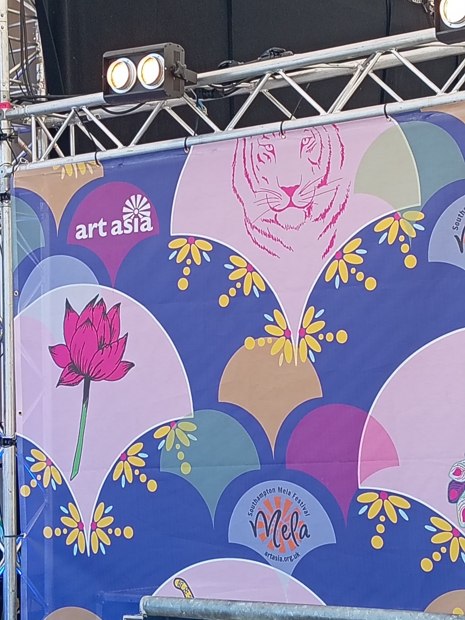 Banner with blue background featuring overlapping circular designs in pink, purple, and grey. Contains pink lotus flower, tiger illustration, yellow botanical elements, and "art asia" text.