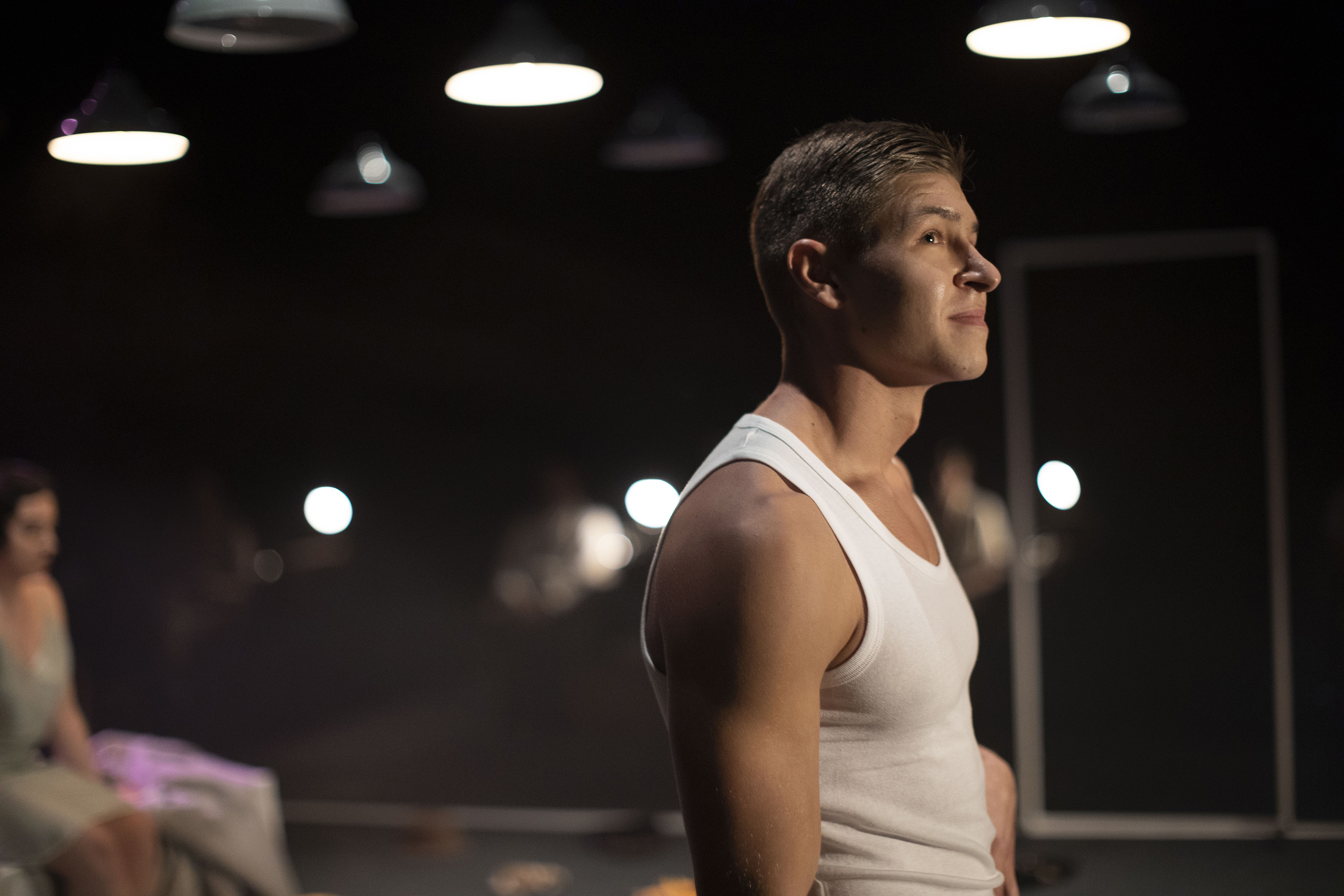 Close-up of an actor wearing a vest, viewed from the side.