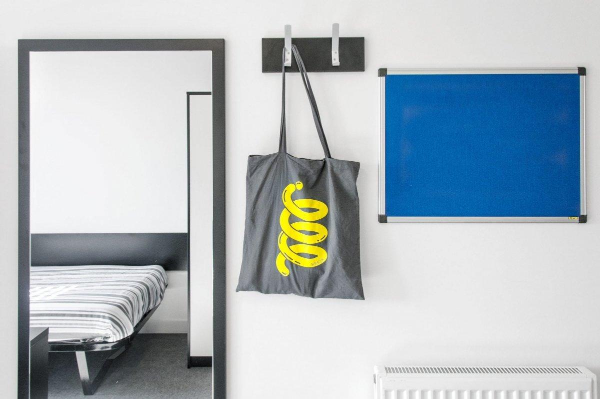 Mirror and coat hooks hung on the wall of a Madeira Road bedroom wall