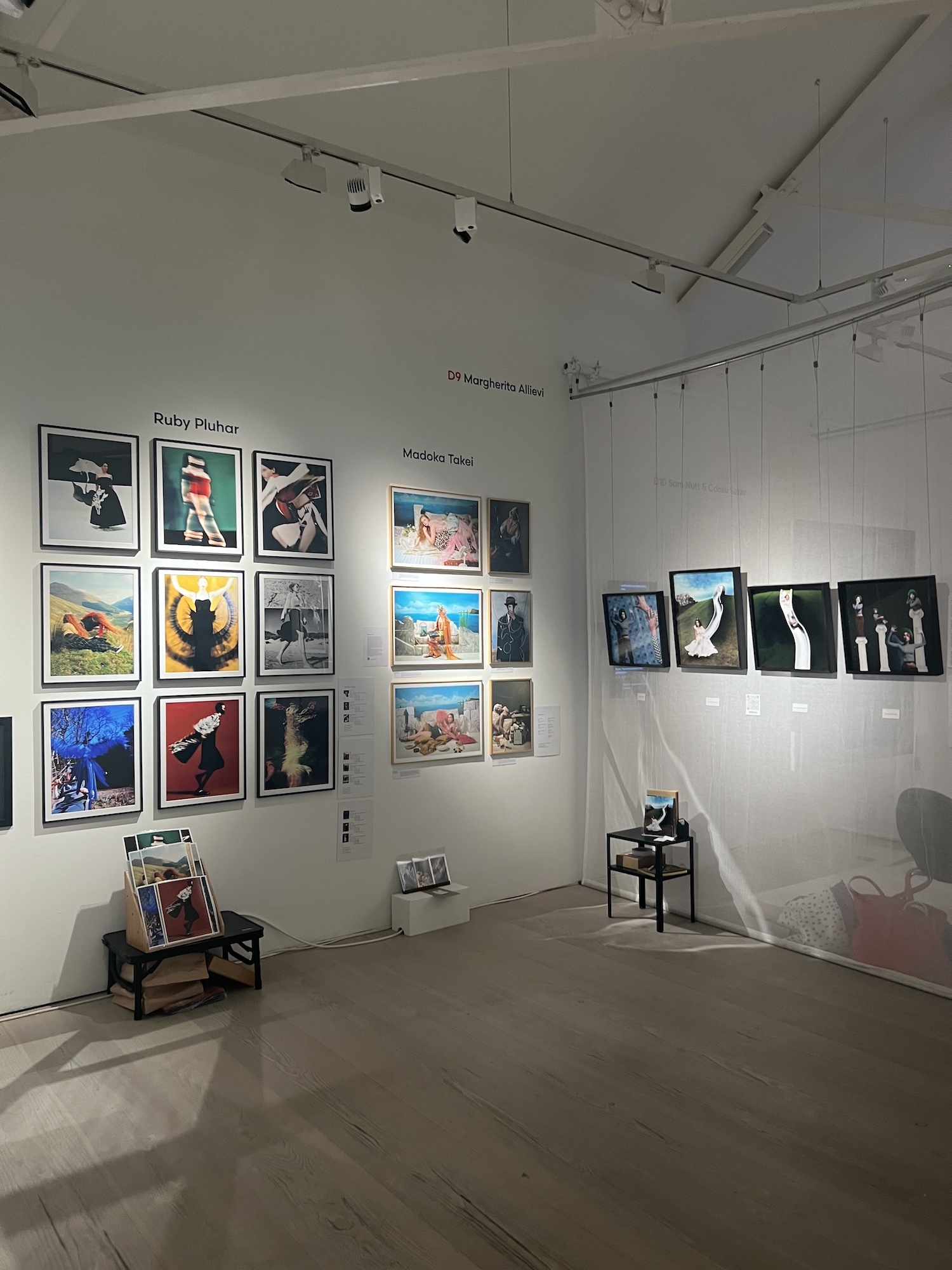 Corner of the Saatchi Gallery, London, during the British Art Fair displaying framed artworks on white walls, with small easel and table showing additional prints on concrete floor.