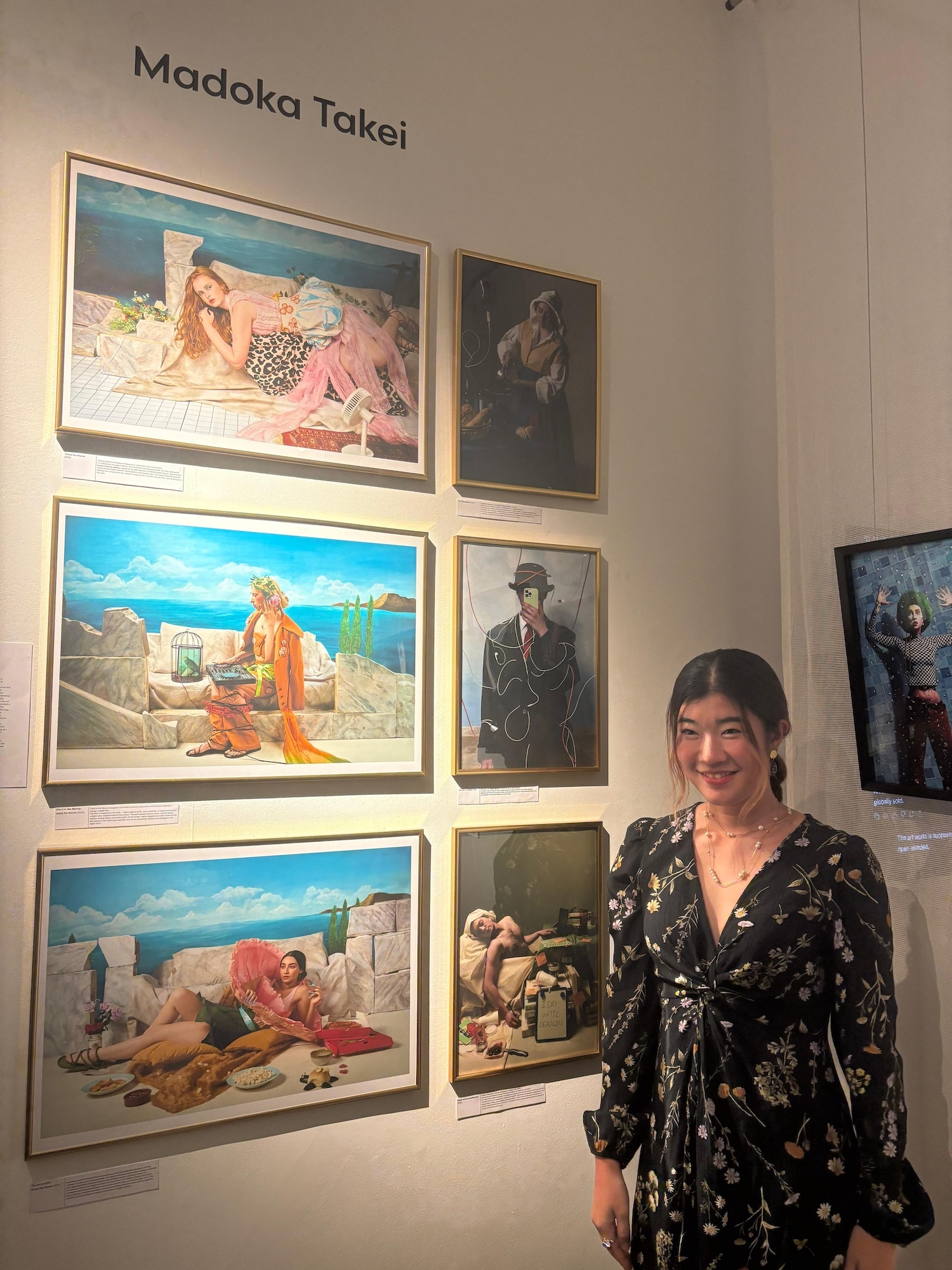 M Takei standing beside gallery wall displaying six framed artworks under "Madoka Takei" heading on white wall.