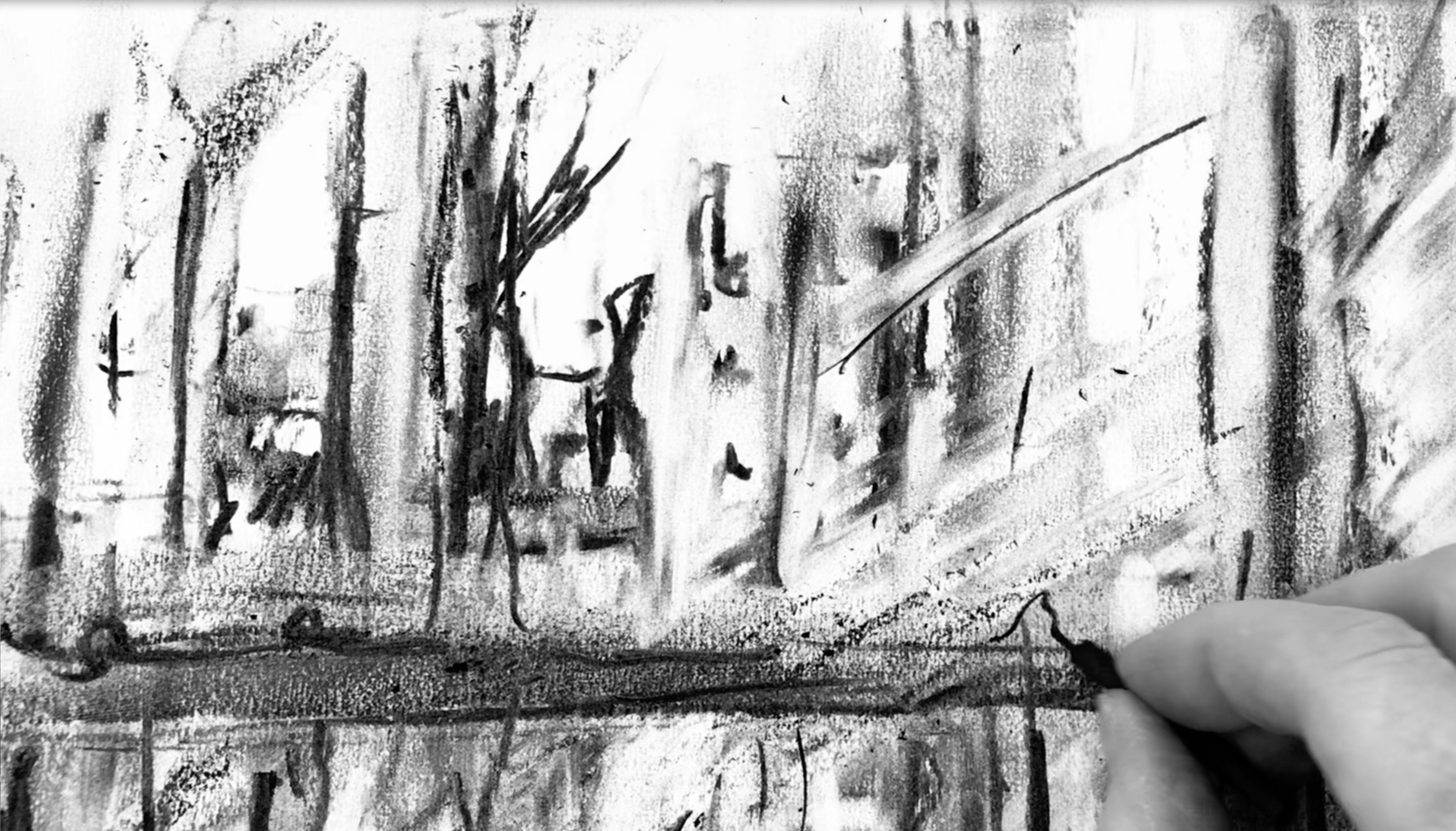A series of pencil marks on a page. A hand in the middle of drawing appears in the bottom-right corner