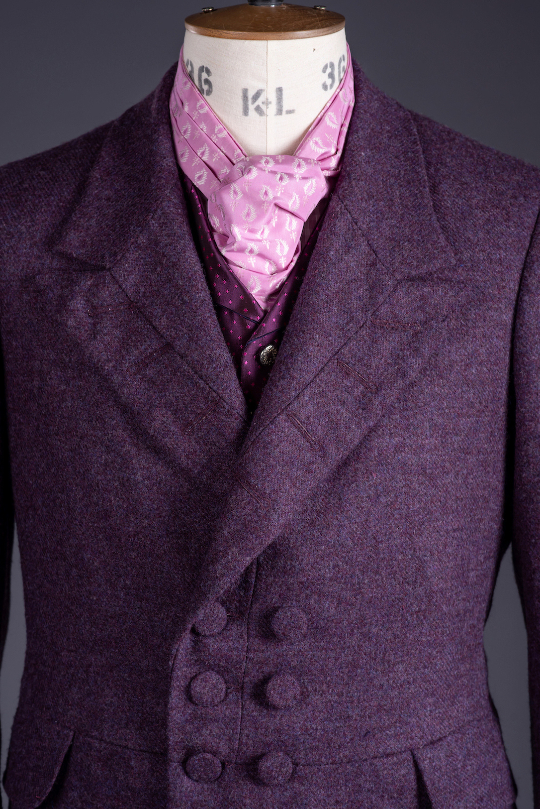 Close-up of a purple men's 19th century double-breasted jacket on a mannequin.