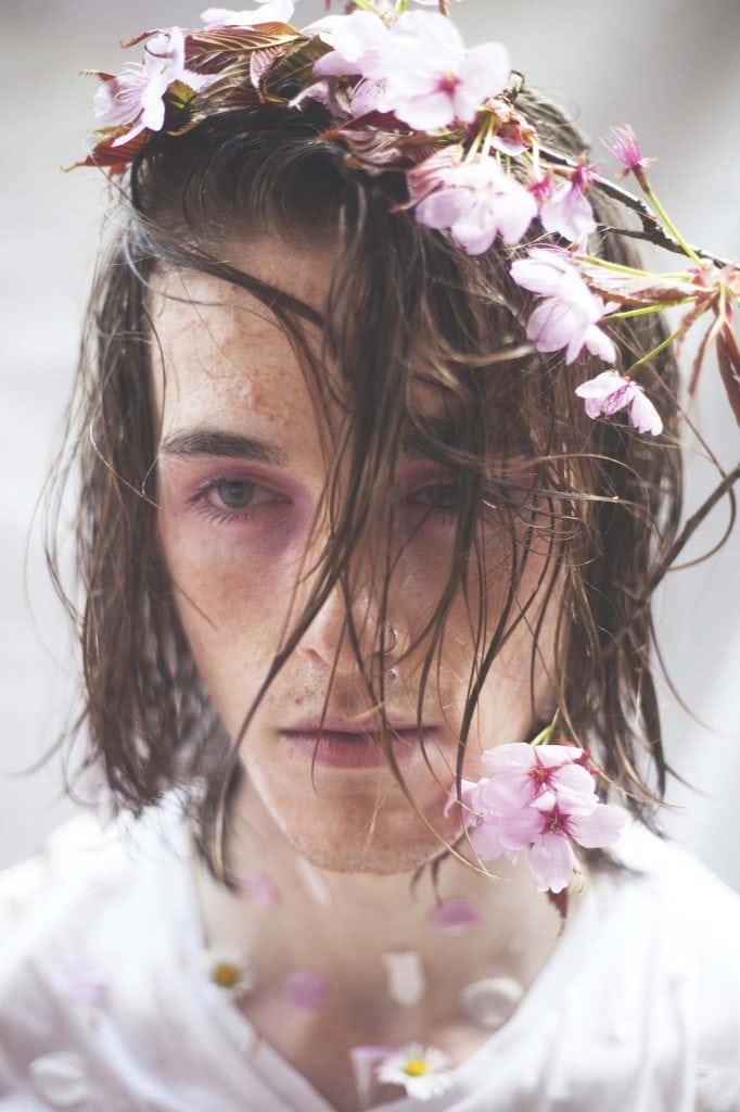 Close up of a model with flowers in their hair.