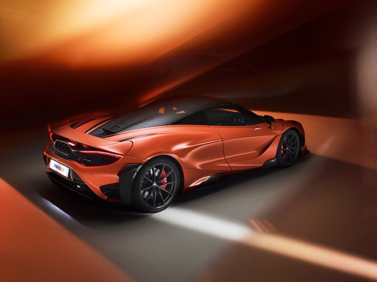 An orange McLaren on an abstract orange background.