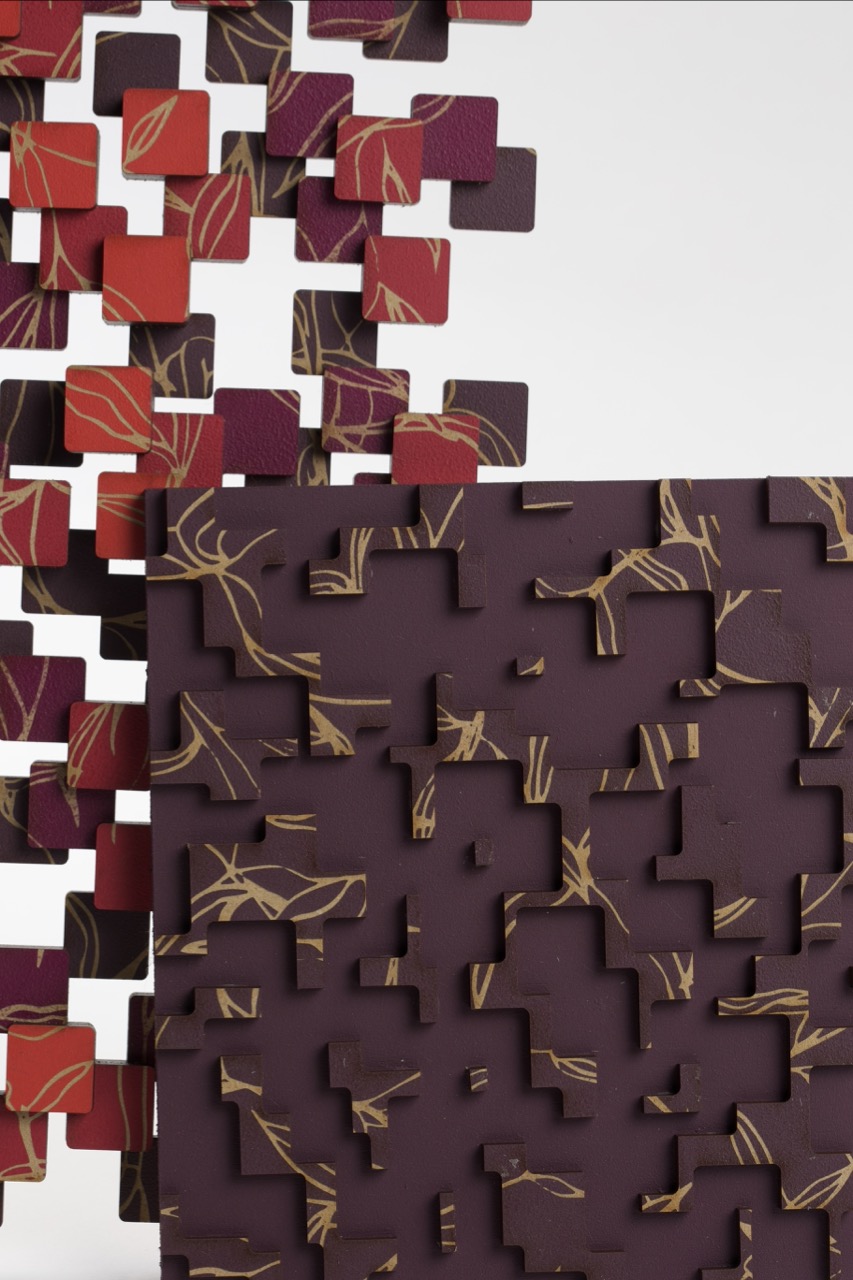 An artistic arrangement of puzzle pieces in various shades of purple and red, featuring intricate patterns. The pieces are disassembled and appear to float above a solid section, highlighting their designs against a white background.