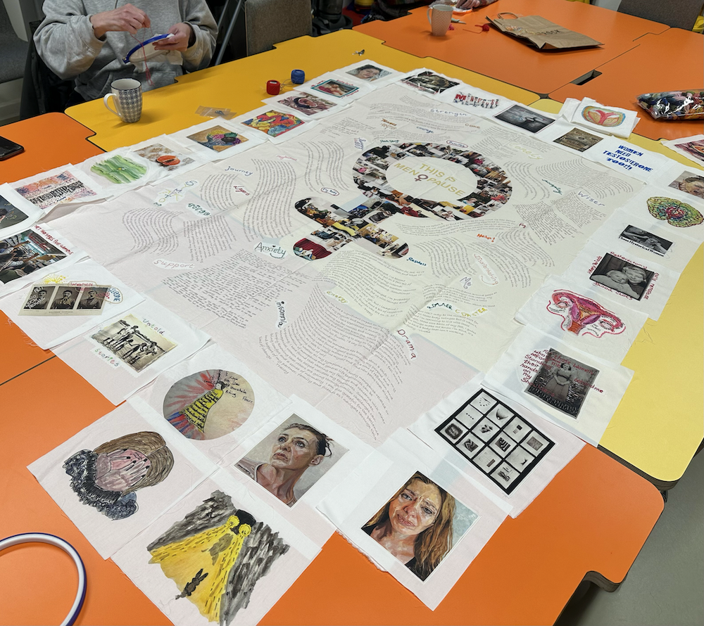 Several panels, with a border of images, ready to be put together as a quilt. A female symbol is formed in the centre.