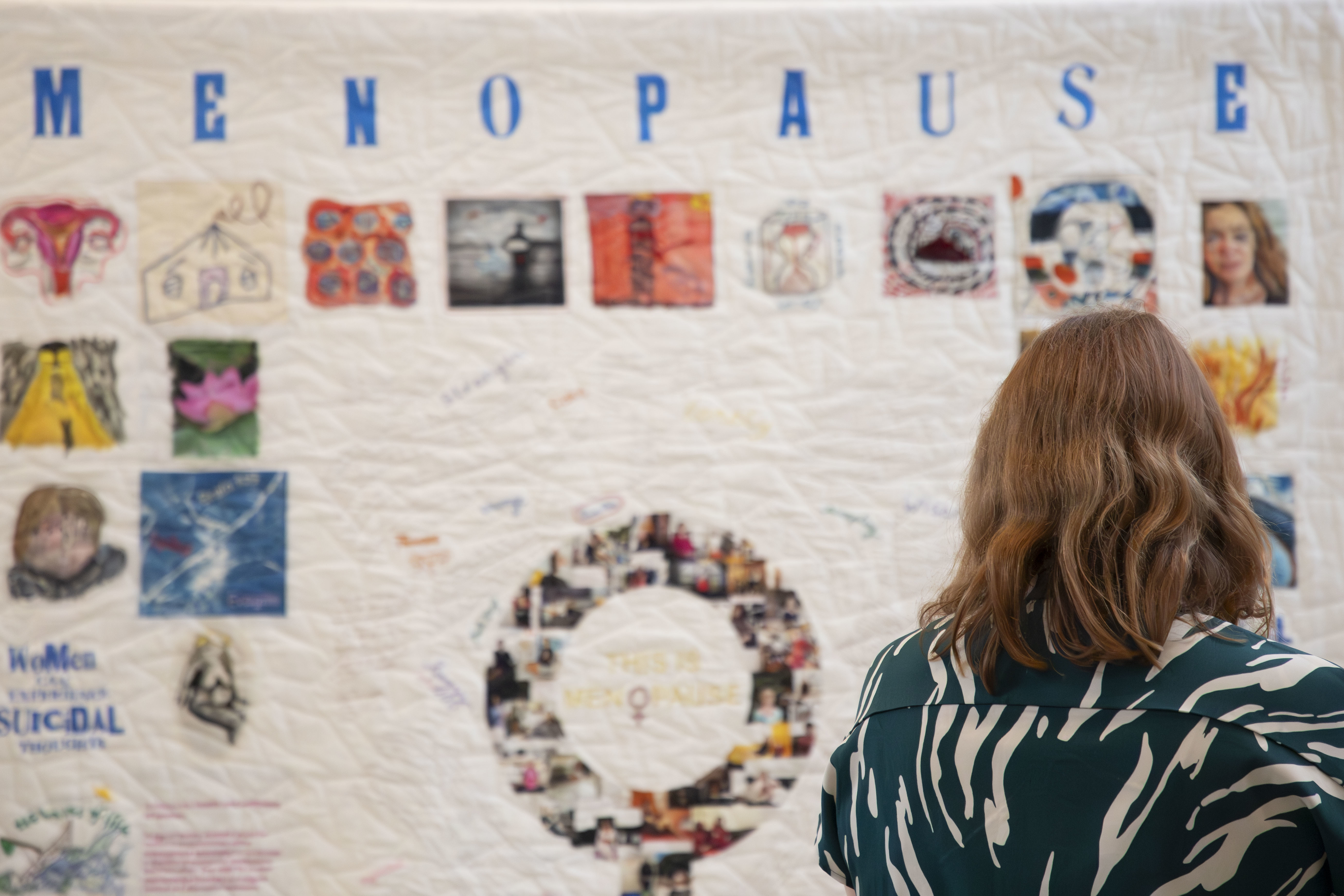 A woman viewed from the back looking at a giant quilt, made up of several images. The word "Menopause" is formed along the top of the quilt.