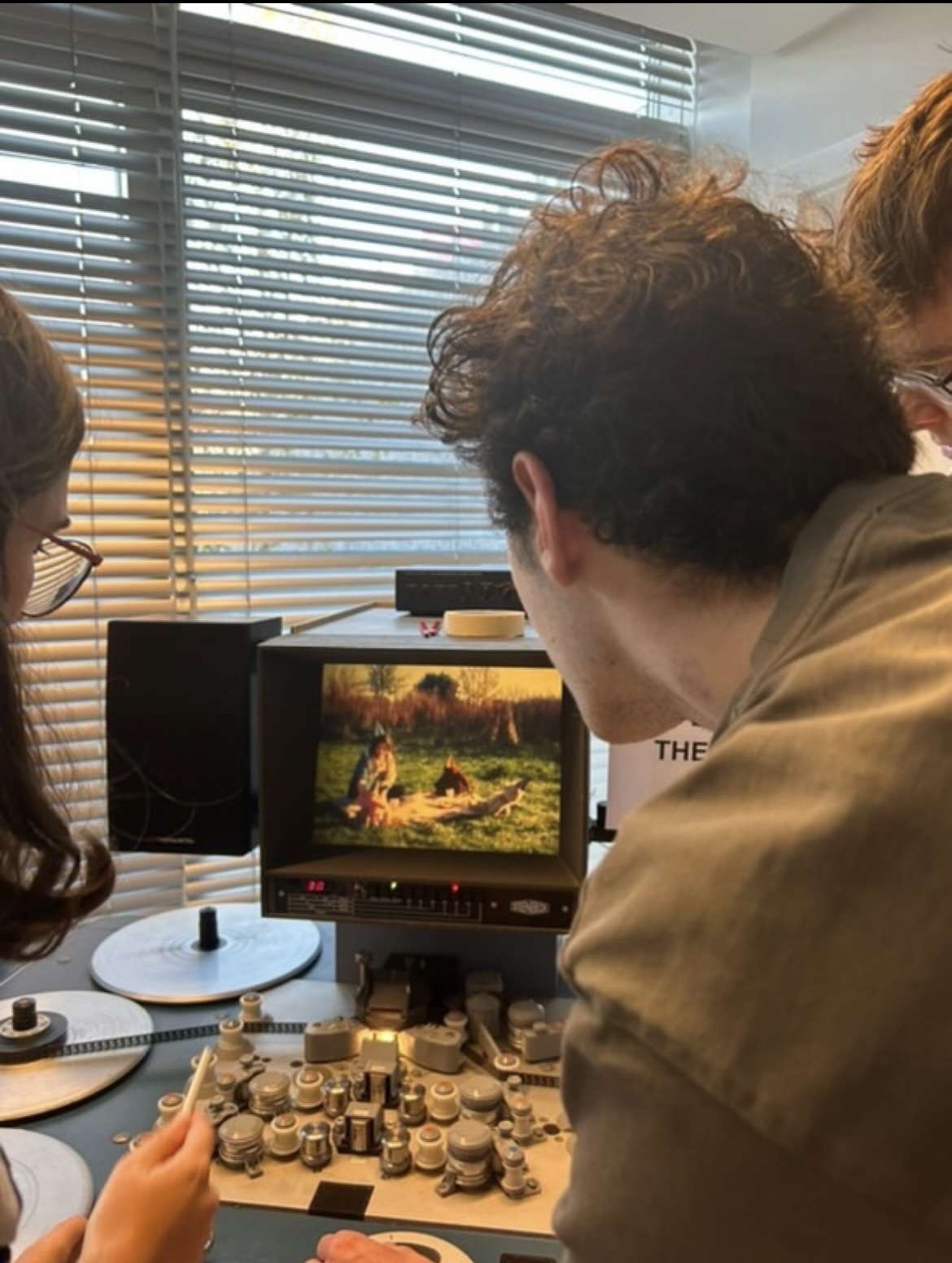 BA (Hons) Film Production students viewed from the back, watching a Celluloid film on a small monitor.