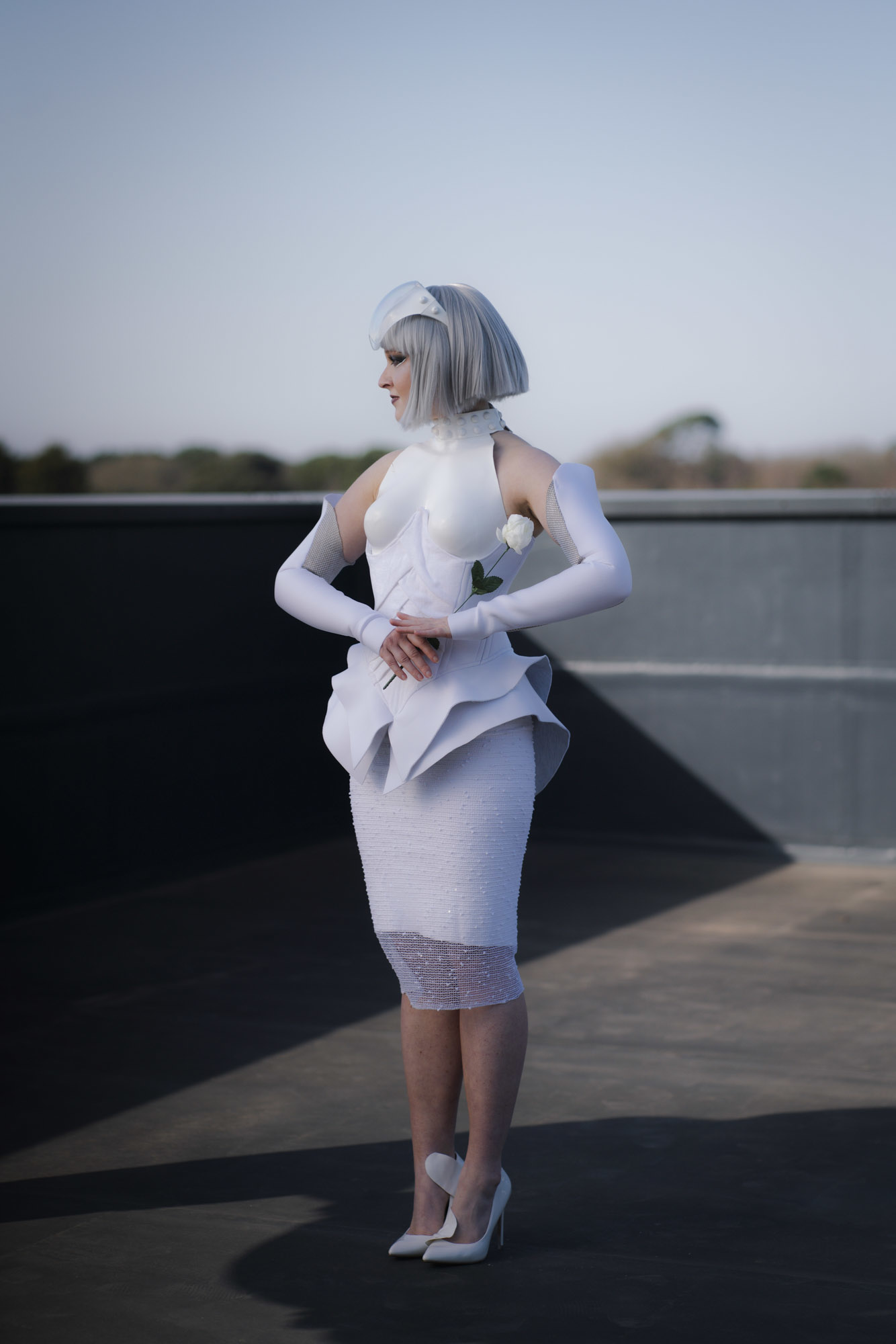 A model in a Hunger Games-inspired costume stands and looks off to the left.
