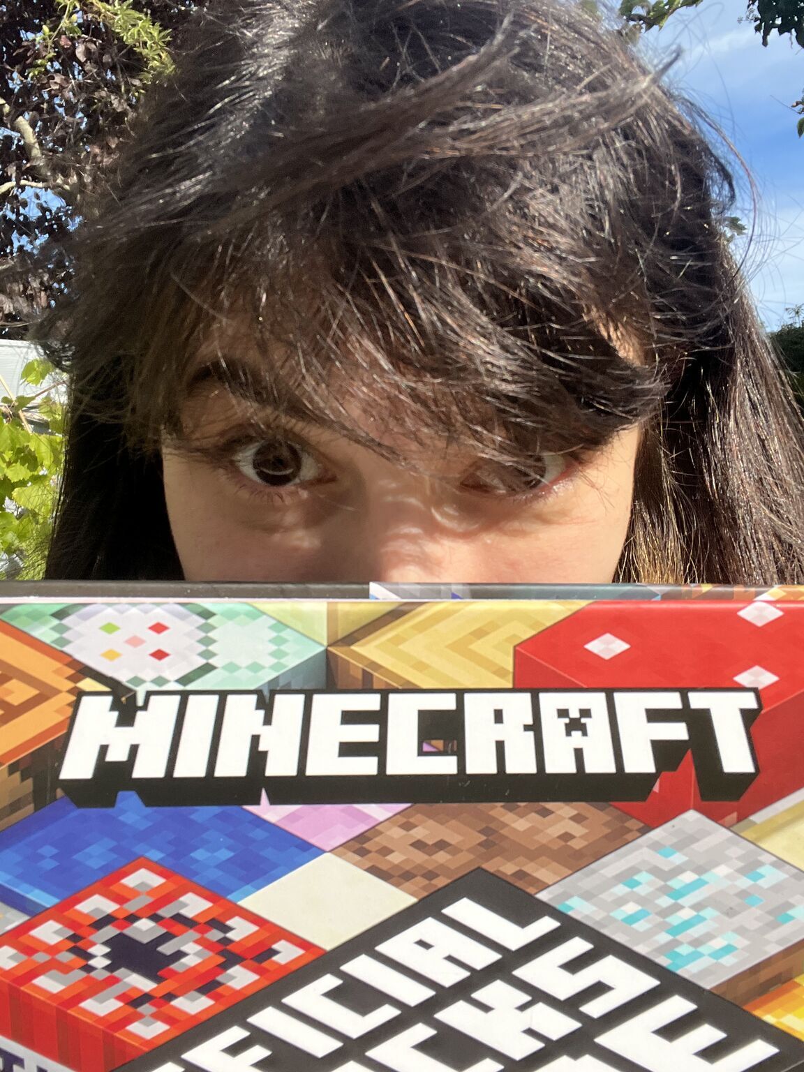 Close up of O. Erdenlig with a copy of the Minecraft Official Blocks Guide partly visible in the lower half of the image.