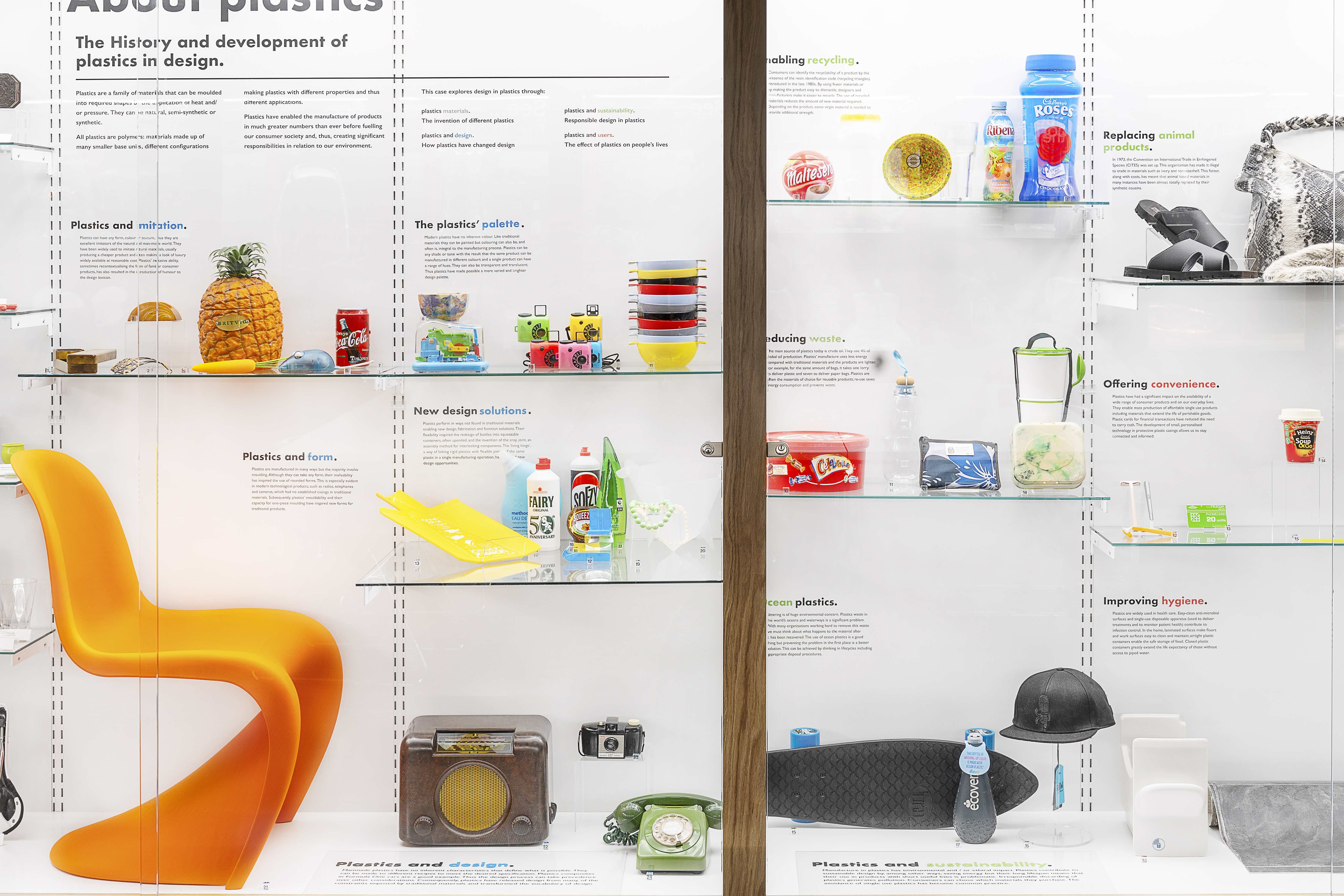 Display of colourful plastic objects on glass display shelves in the MoDiP museum, AUB campus.