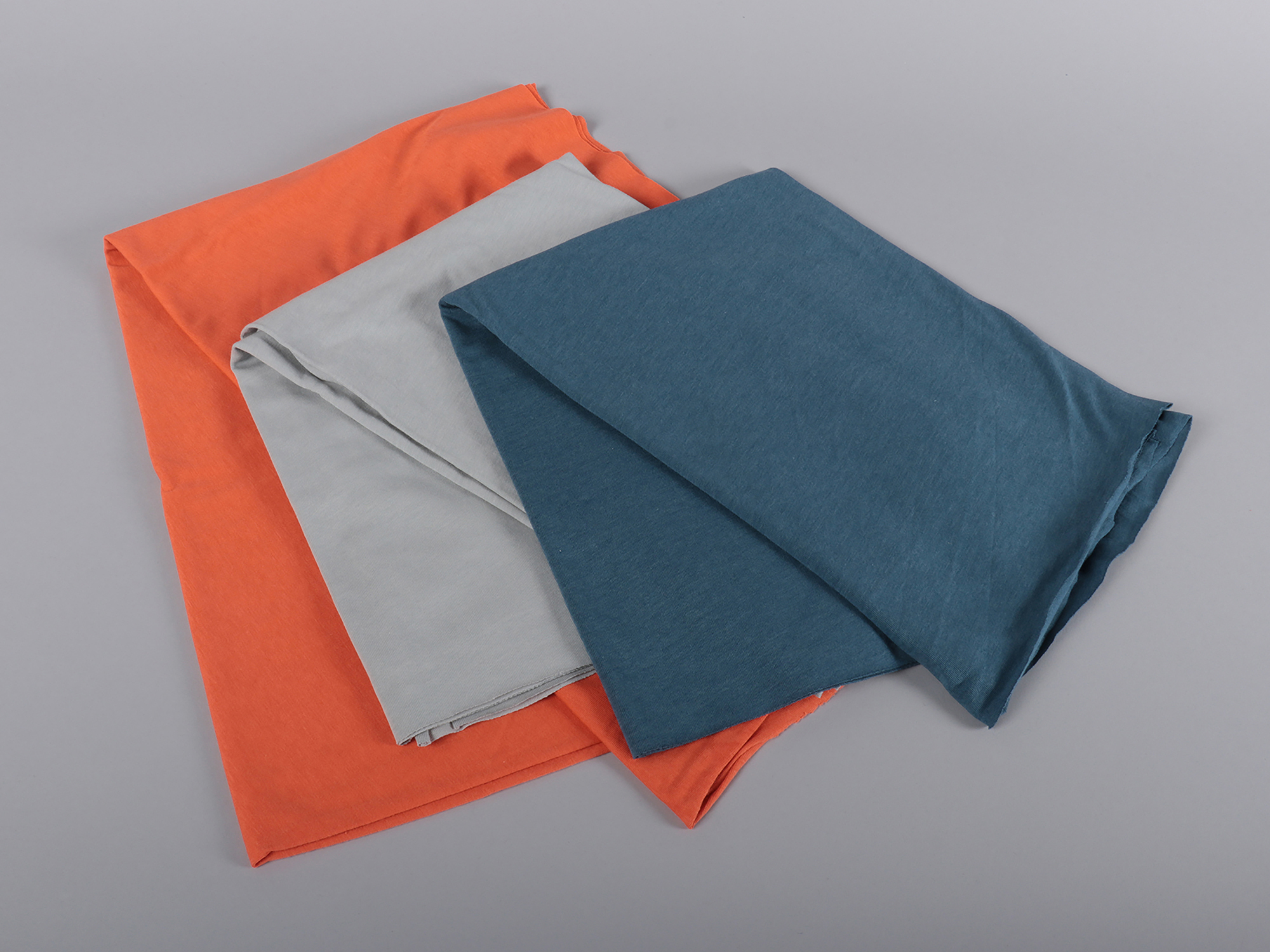 Three colourful fabric samples, folded and displayed on top of one another.