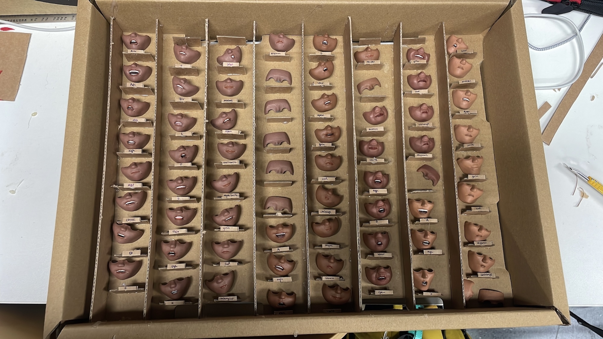 A box containing a large number of mouth pieces for stop motion animation models.