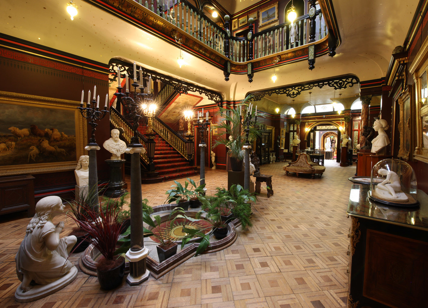Main hall space at the Russell-Cotes museum and art Gallery. A grand staircase surrounded by art and sculptures