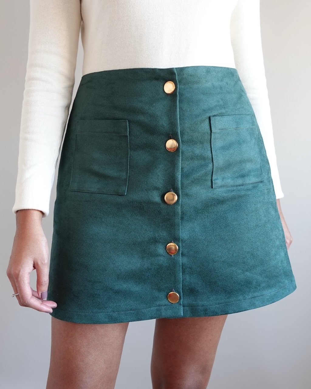 Close-up of Tammy Johal's 'Simi' skirt, teal with gold buttons.