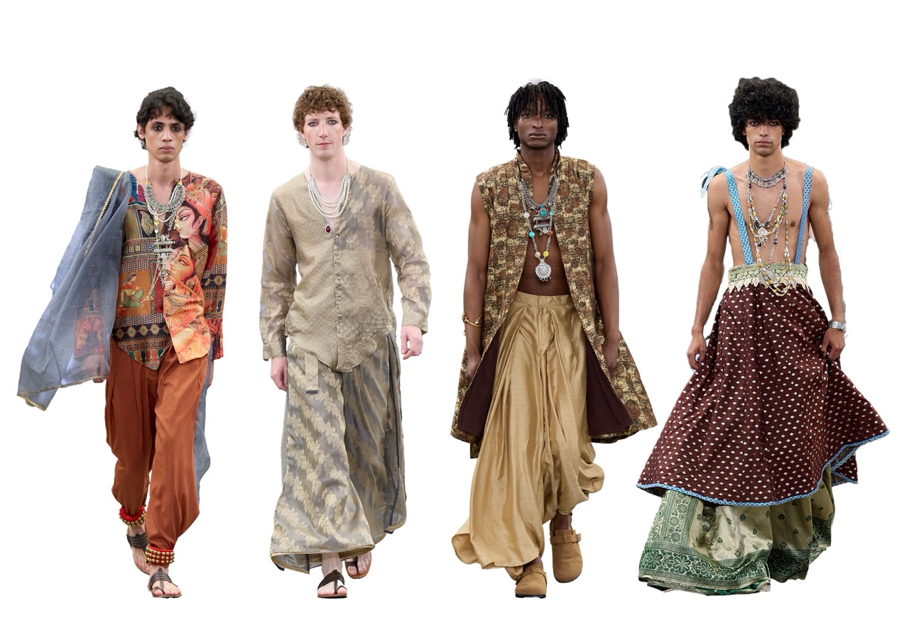 Four male fashion models walk together against a white background, wearing layered bohemian outfits in earthy tones and patterned fabrics.