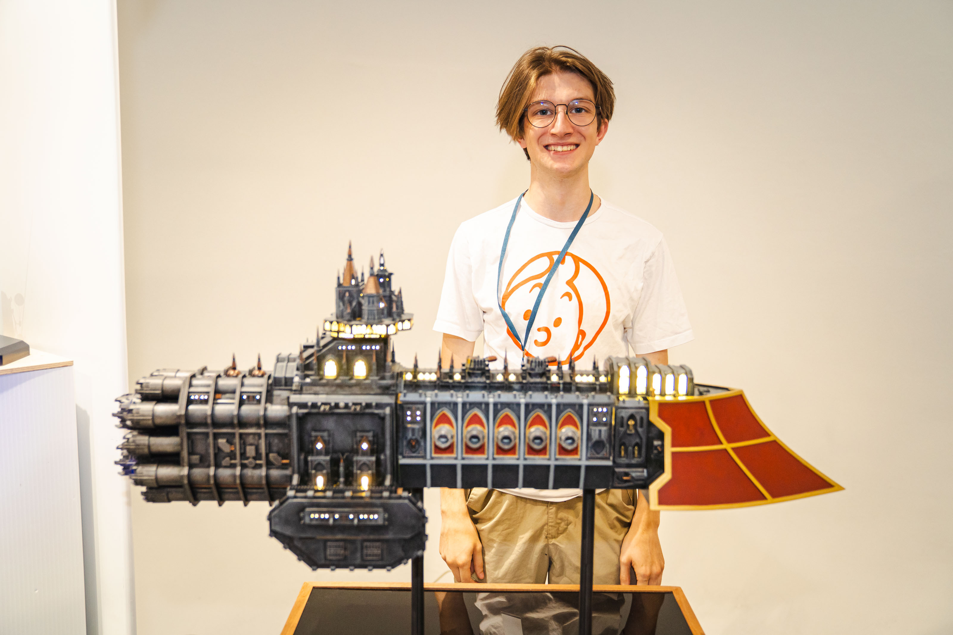 BA (Hons) Modelmaking graduate K Jones standing behind detailed Gothic-inspired spaceship model on display stand.