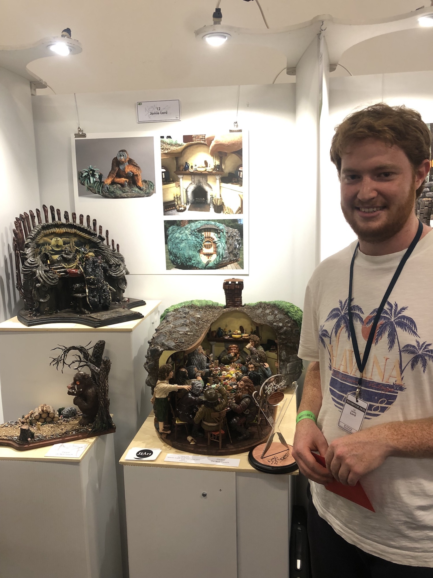 BA (Hons) Modelmaking student Jamie Lord standing next to models of a scene from The Hobbit: An Unexpected Journey, Pirates of the Caribbean, and The Gruffalo.