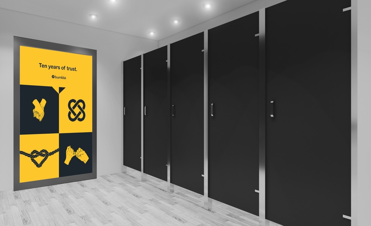 Bathroom advertising branding for the ’10 Years of Trust’ campaign, yellow and black graphics.