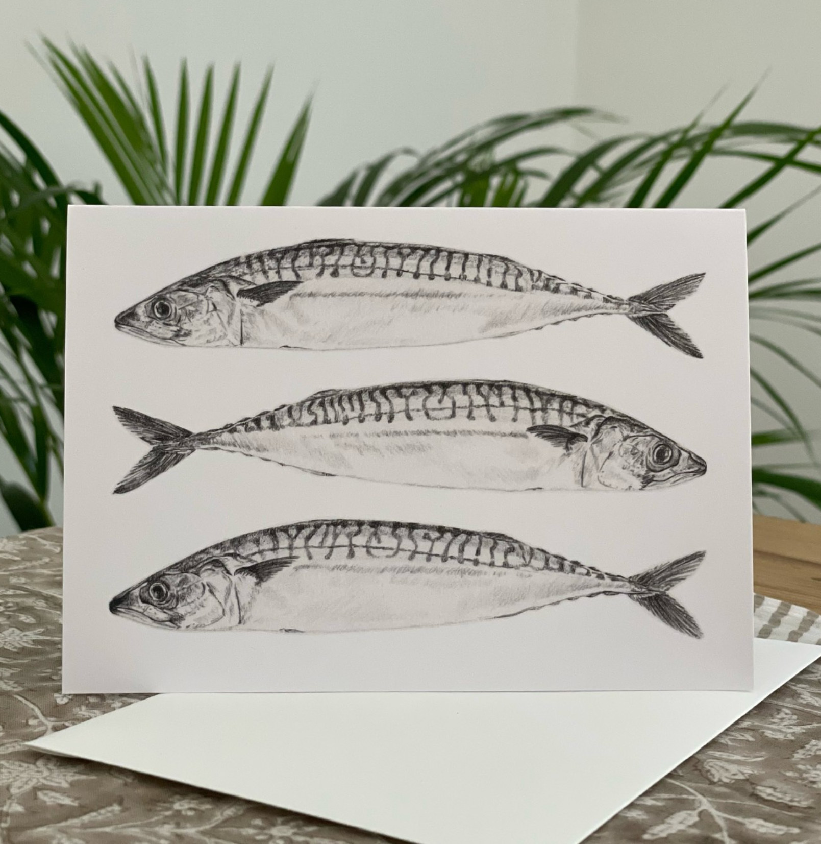 Greetings card with three pencil-drawn fish illustrations