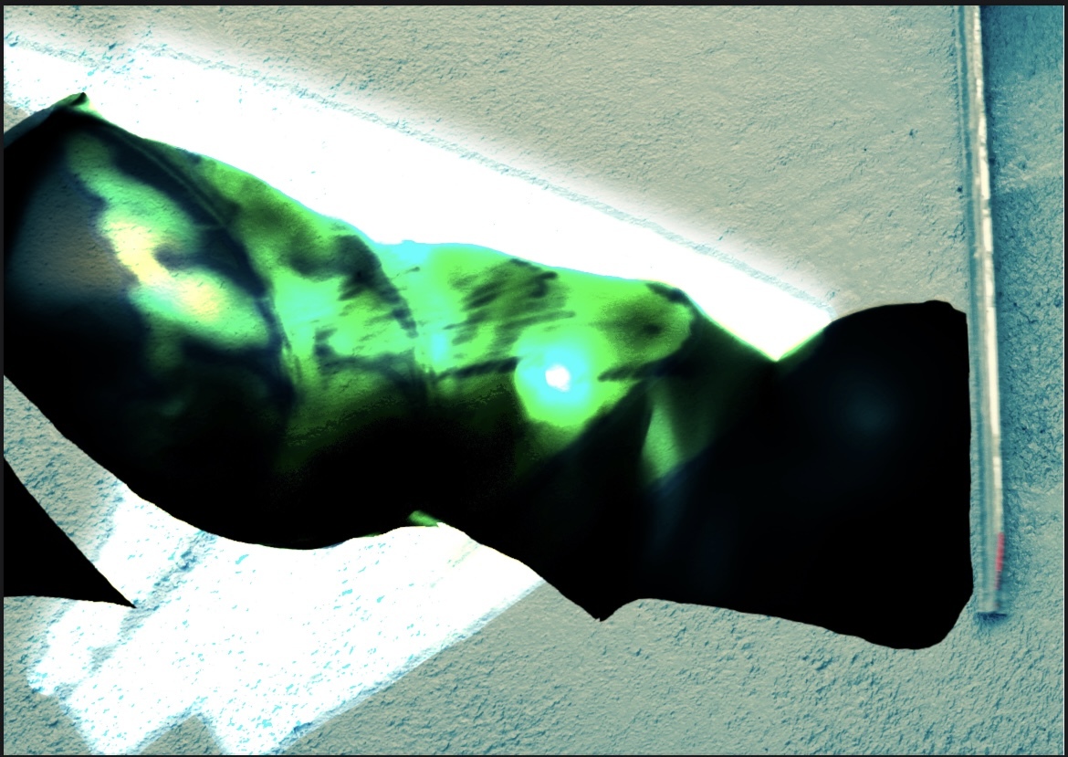 Blurred silhouette with green light reflecting through it, concrete white background.