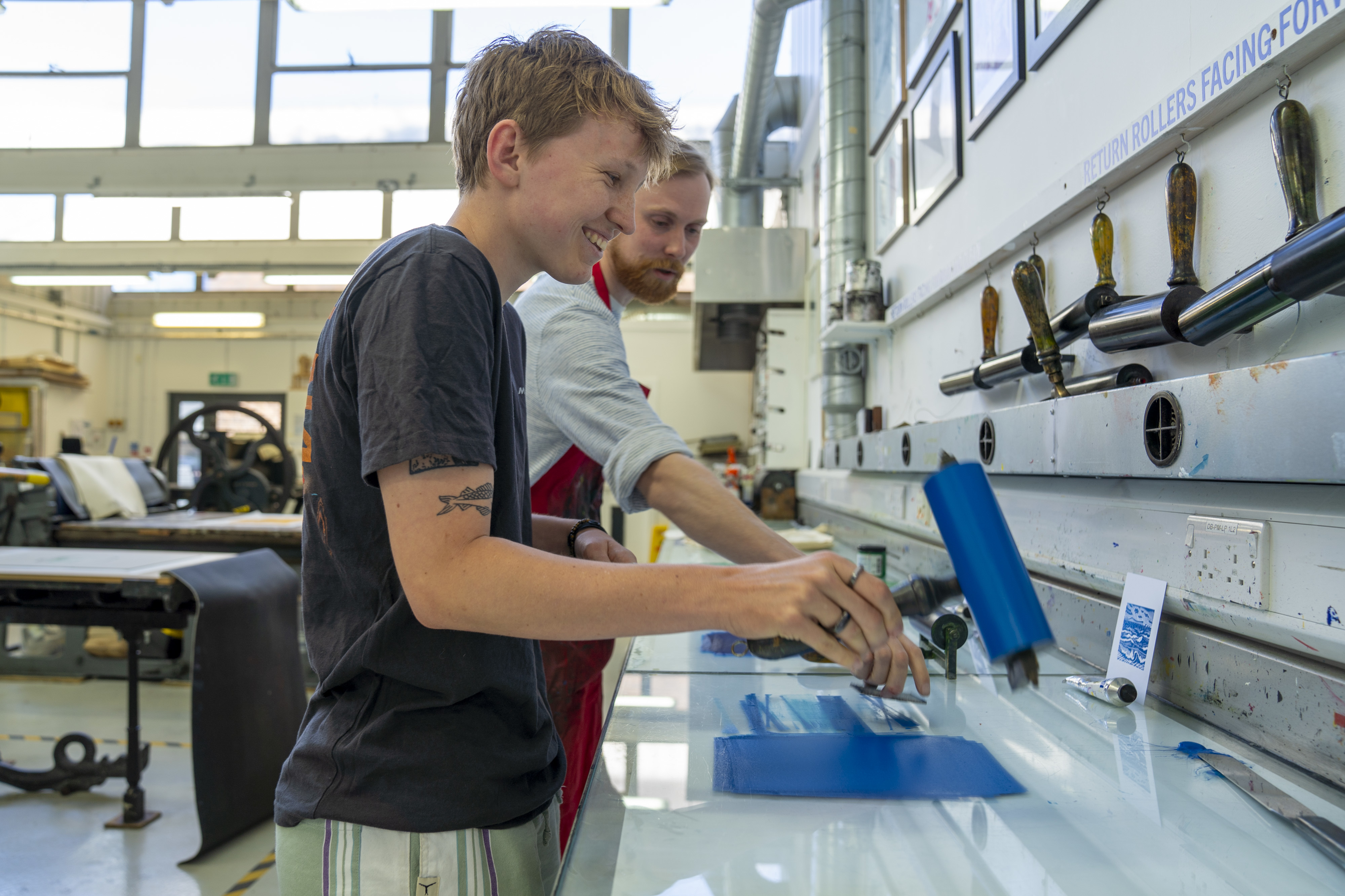 A prospective student trying out a blue print at the Open Day printmaking workshop.