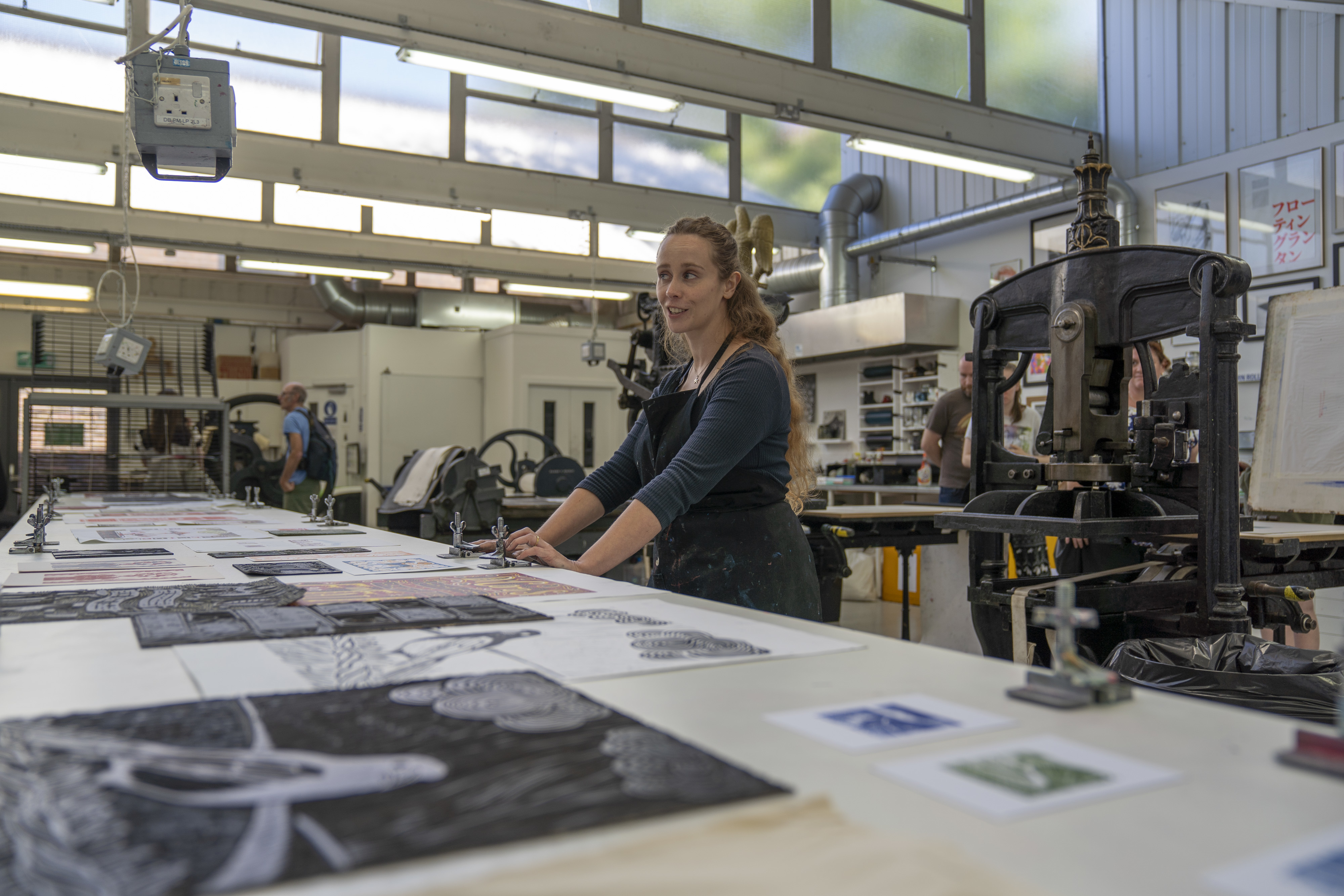 Printmaking workshop at Open Day with a woman in a studio with equipment.