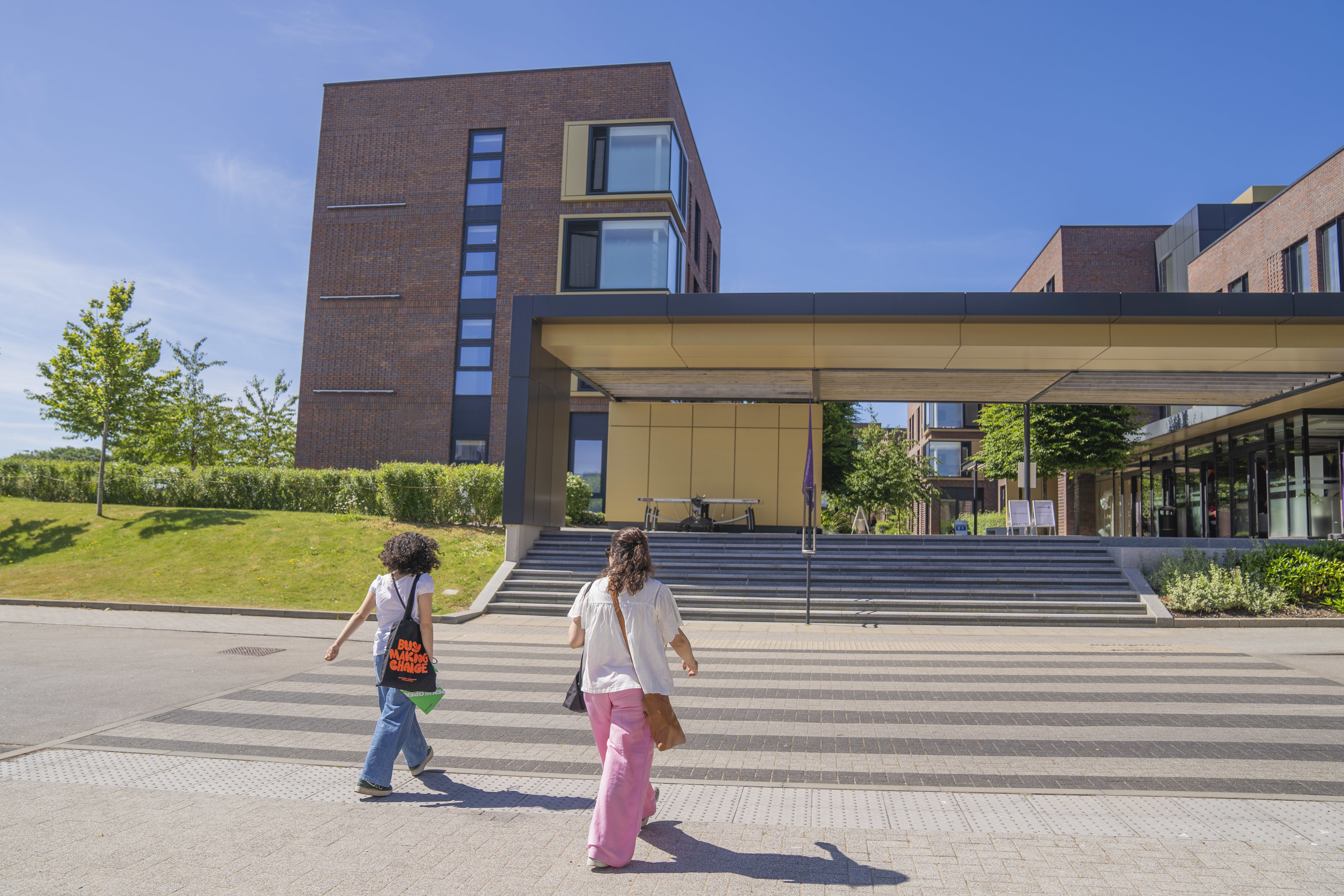People walking towards AUB on-campus accommodation, sunny weather and blue sky.