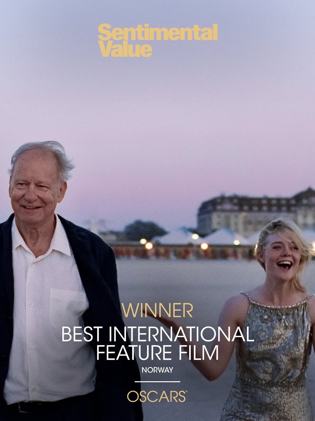 Film poster with purple-pink sky background. Older man in dark jacket and white shirt stands beside blonde woman in sparkly dress. Yellow text at top, white award text at bottom.