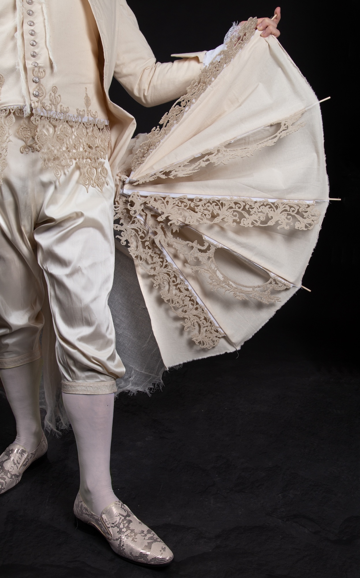 Close-up of a panel of a cream-coloured 18th century tailcoat with a panel raised and spread out like a wing.