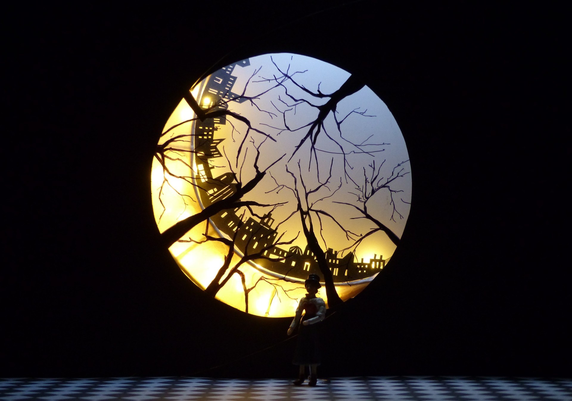Fish-eye view of some dead trees and a cityscape behind it.
