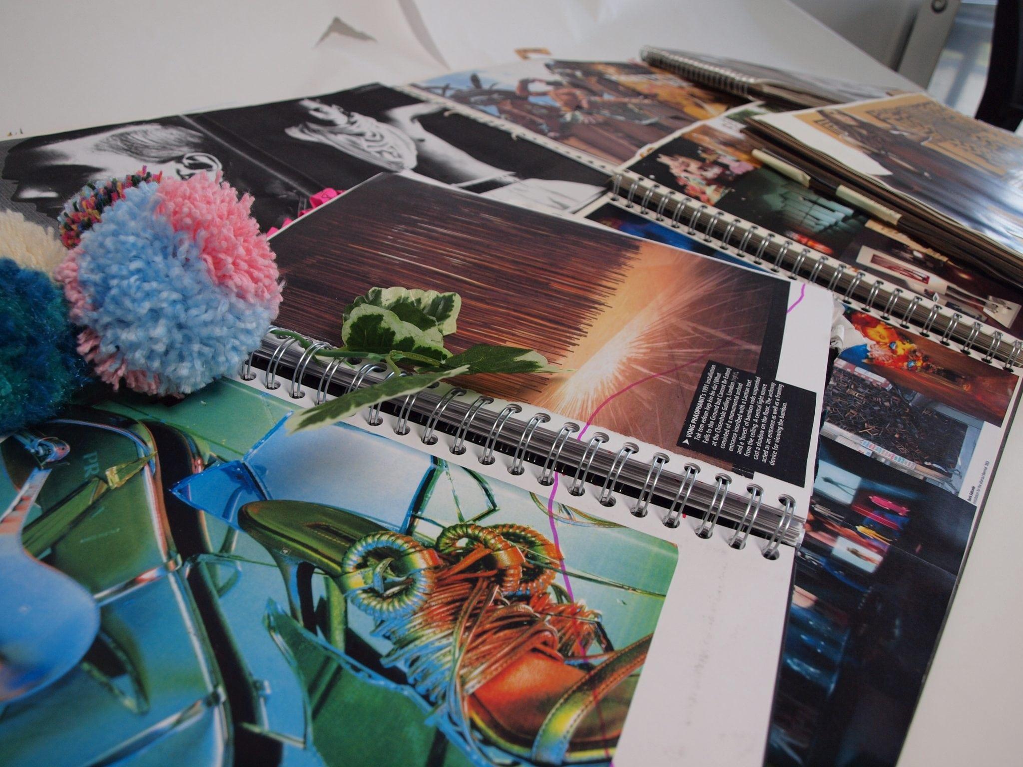 Open portfolio books lying on top of one another across a table.
